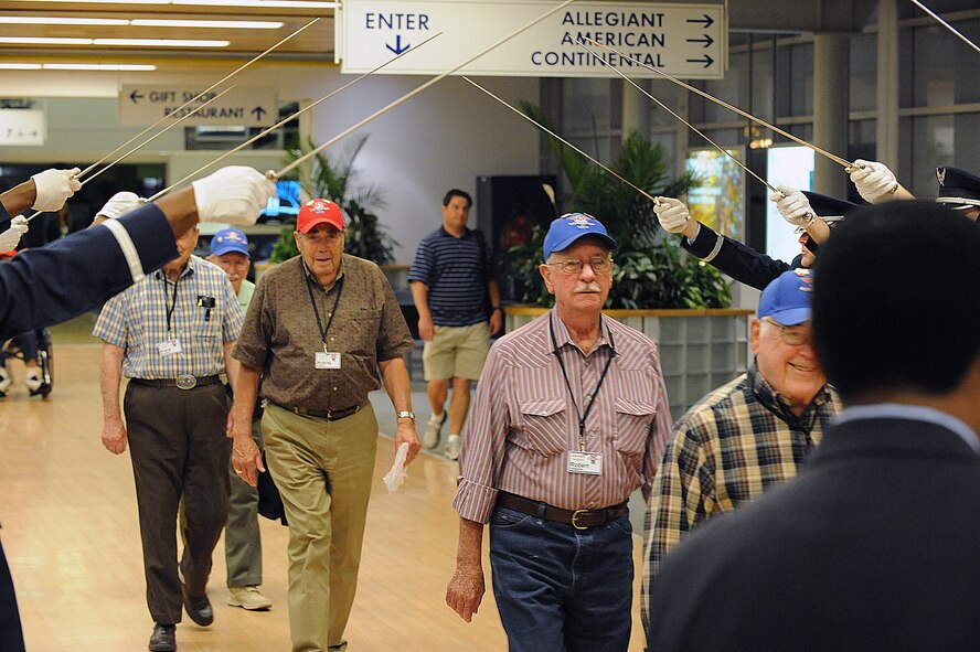 World War II veterans walk through the Honor Guard cordon after returning from a trip to Washington D.C. at the Shreveport Regional Airport in Shreveport, La., May 12. The veterans visited the capital to see the World War II monument for their first time. Barksdale and the local community welcomed the veterans home to show support and gratitude. (U.S. Air Force photo/Airman 1st Class Micaiah Anthony)(RELEASED)