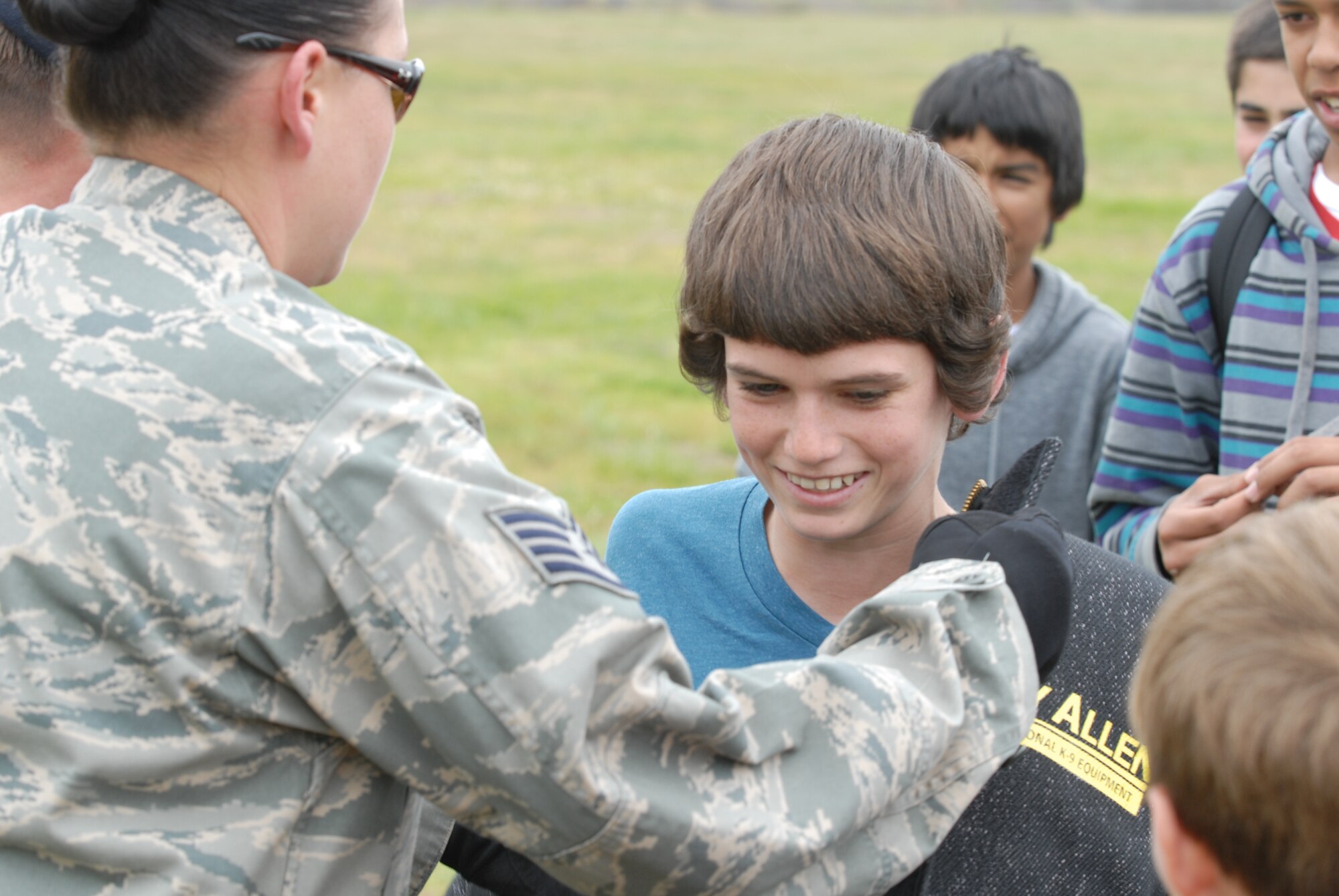 VANDENBERG AIR FORCE BASE, Calif. -- Staff Sgt. Terri Messina, a 30th Security Forces Squadron military working dog trainer, helps a Vandenberg Middle School student try on a bite jacket at a National Police Week event Monday, May 16, 2011. National Police Week, which occurs annually during the week of May 15, recognizes the service and sacrifice of U.S. law enforcement personnel. (U.S. Air Force photo/Jerry E. Clemens, Jr.)
