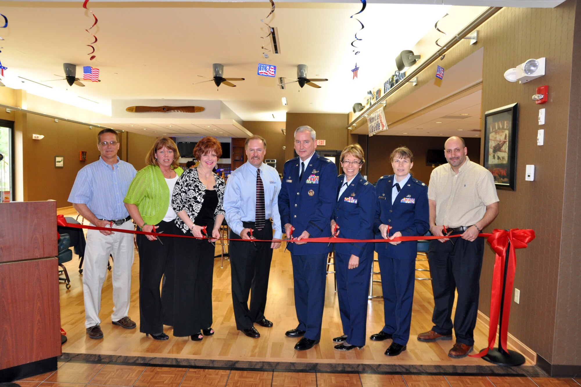 YOUNGSTOWN AIR RESERVE STATION, Ohio -- A group of dignitaries, including 910th Airlift Wing commander, Col. Fritz Linsenmeyer (fifth from left) and Air Force Reserve Command (AFRC) Deputy Chief of Services, Mr. Alan Ray (fourth from left) prepare to cut the ceremonial ribbon, officially opening the new Community Activity Center (CAC) here, May 14, 2011. According to Mr. Ray, the 910th's CAC is the first constructed on an AFRC base. The new concept combines the air station's dining facility, now known as Herk's Place, with the club, named the C-130 Bar and Grille in honor of the aircraft assigned to YARS, as well as a recreation activities room in one facility to enhance the services provided to the wing's Citizen Airmen and other guests. U.S. Air Force photo by Master Sgt. Bob Barko Jr.