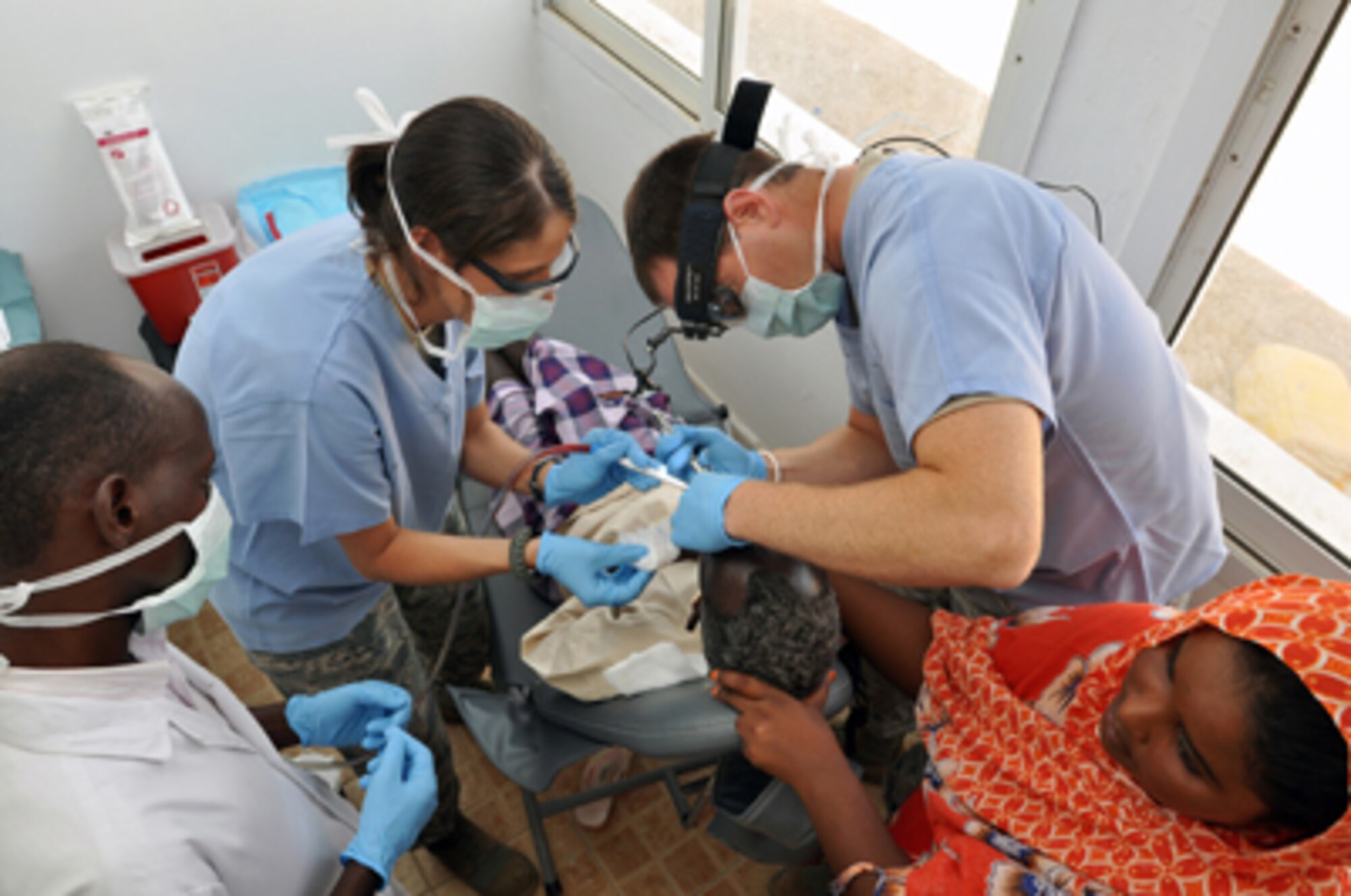 Staff Sergeant Leah Potter and Captain Robert Spriggel treat a dental patient May 5, 2011, during a Medical Capacity Program mission in Obock, Djibouti. Dentists attached to Combined Joint Task Force -- Horn of Africa cared for Obock citizens with periodontal diseases. The MEDCAP also featured optometric and preventative care performed by 20 service members attached to CJTF-HOA. (U.S. Air Force photo by Lt. Col. Leslie Pratt)
