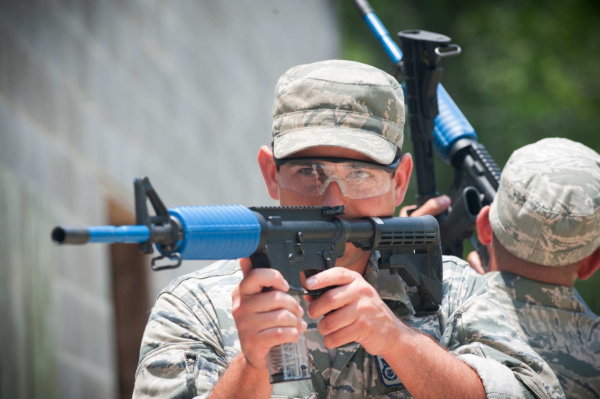 MOODY AIR FORCE BASE, Ga -- Airman 1st Class Nicholas Koch, 822nd Base Defense Squadron fire team member, looks down the barrel of his M4 assault rifle during a military operations in urban terrain scenario May 13. Participants used simulated, non-lethal rounds with paint filled tips to track hits on targets.