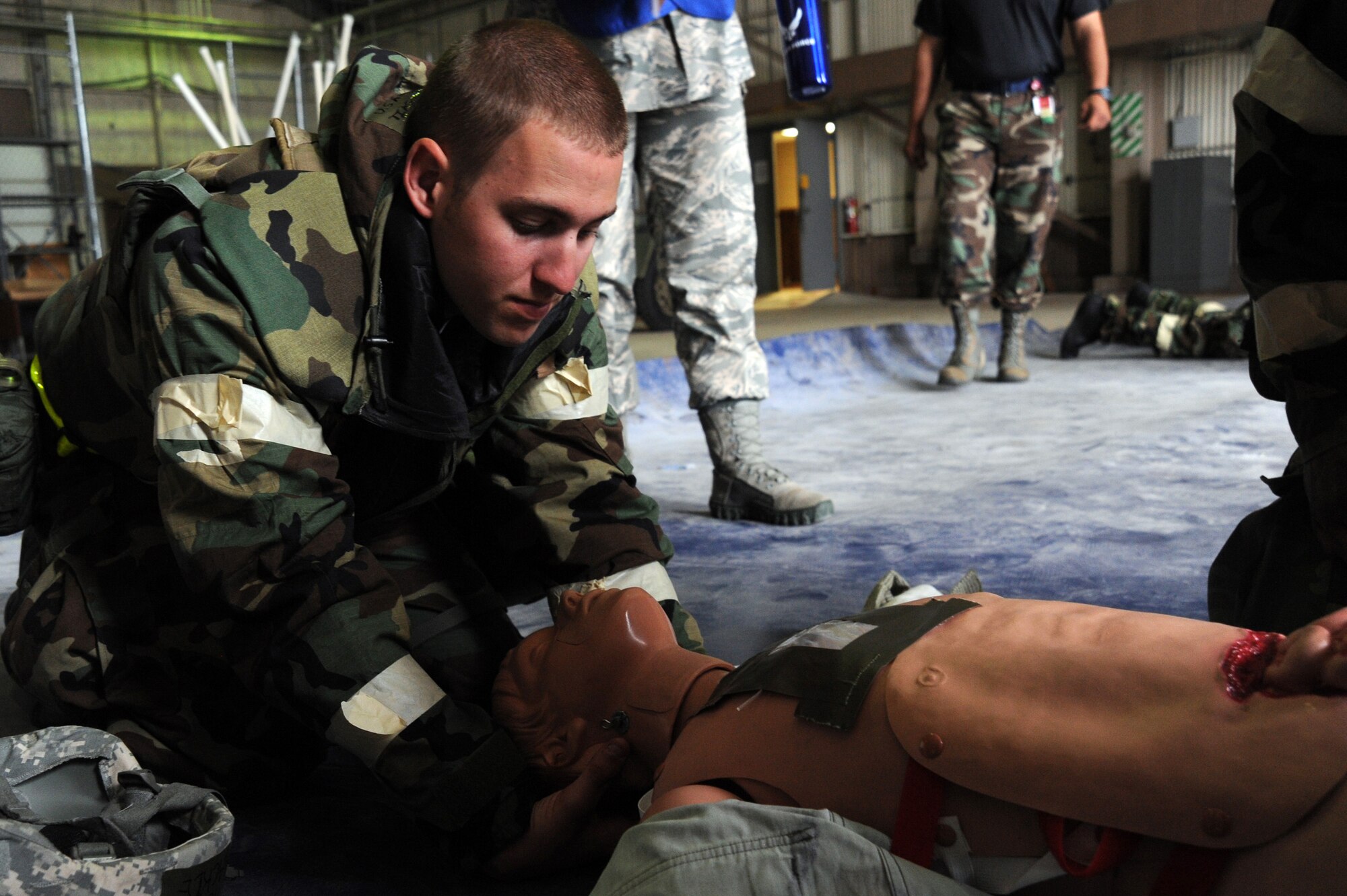 Airman 1st Class Tim Mackie, 22nd Civil Engineer Squadron power production engineer, immobilizes a “victim’s” neck during an operational readiness exercise May 12, 2011, McConnell Air Force Base, Kan. The exercise scenario allows Airmen to practice their abilities in a simulated hostile environment, while executing their primary duties, applying self-aid buddy care and practicing different Mission Oriented Protective Posture conditions. (U.S. Air Force photo/Staff Sgt. Dallas Edwards)
