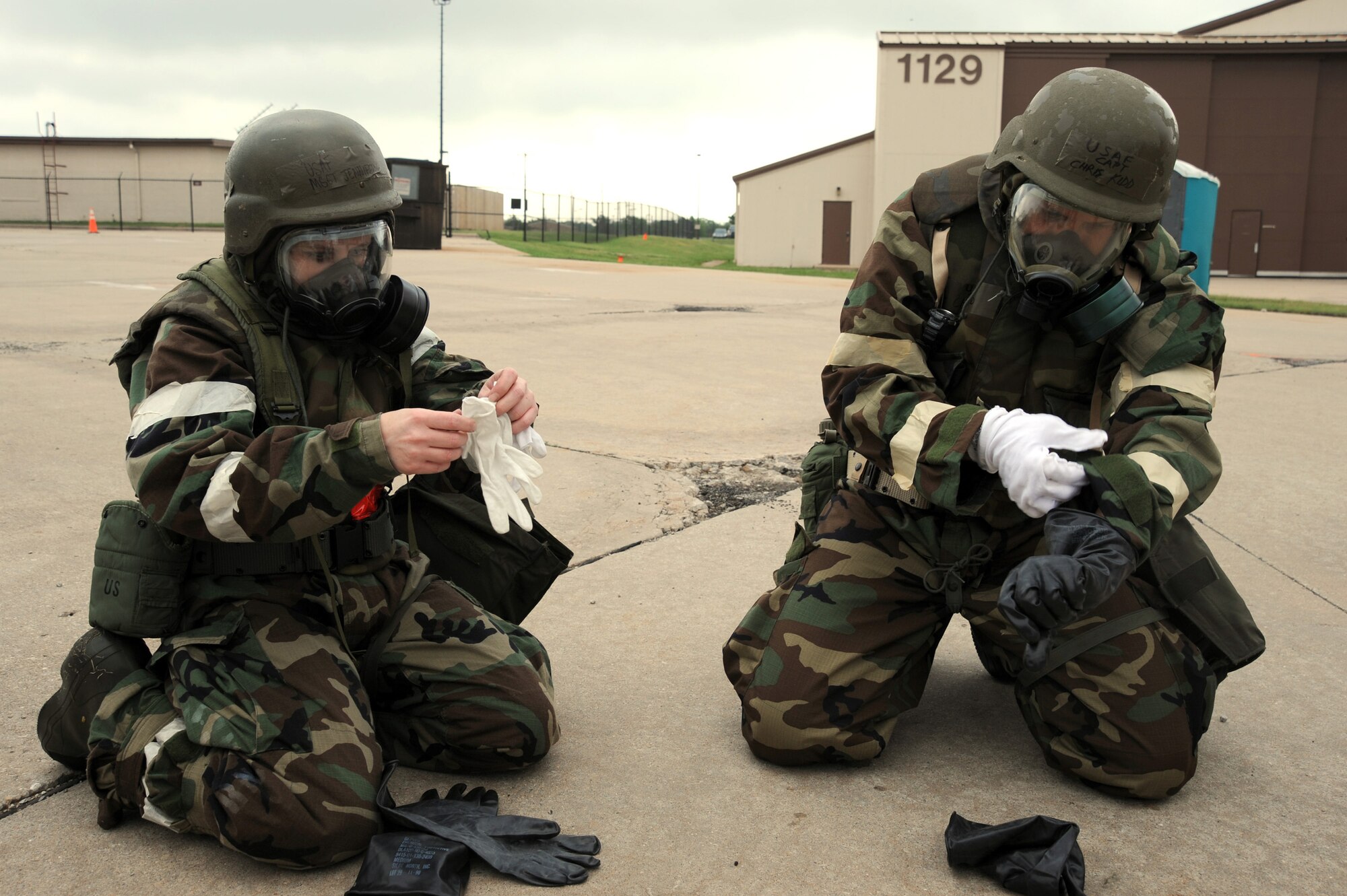 (Left) Master Sgt. Jennifer Bye, 22nd Force Support Squadron and Director of Staff first sergeant, and Capt. Christopher Kidd, 18th Air Refueling Squadron KC-135 Stratotanker pilot, put on J-list protective gear during an operational readiness exercise training scenario May 12, 2011, McConnell Air Force Base, Kan. Team McConnell Airmen participated in the ORE to establish continuity and cohesion between different units during deployments and inspections. (U.S. Air Force photo/Staff Sgt. Dallas Edwards)