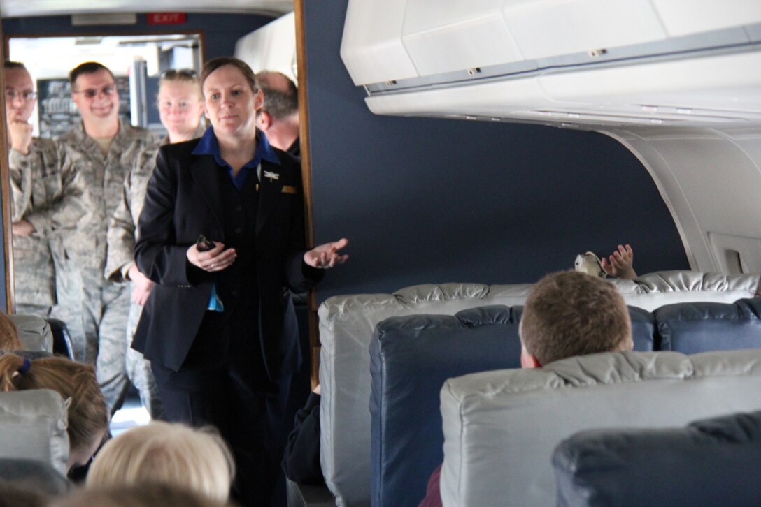 Tech. Sgt. April Tarbill speaks to a group of civilian visitors as she explains the hard work and training required of Air Force Reserve Command flight attendants.  They not only load baggage for guests, but they take care of preparing all meals during a long trip.  Maintainers who take care of the distinguished visitor mission listen behind her.  Photo submitted by Dan Oliver.
