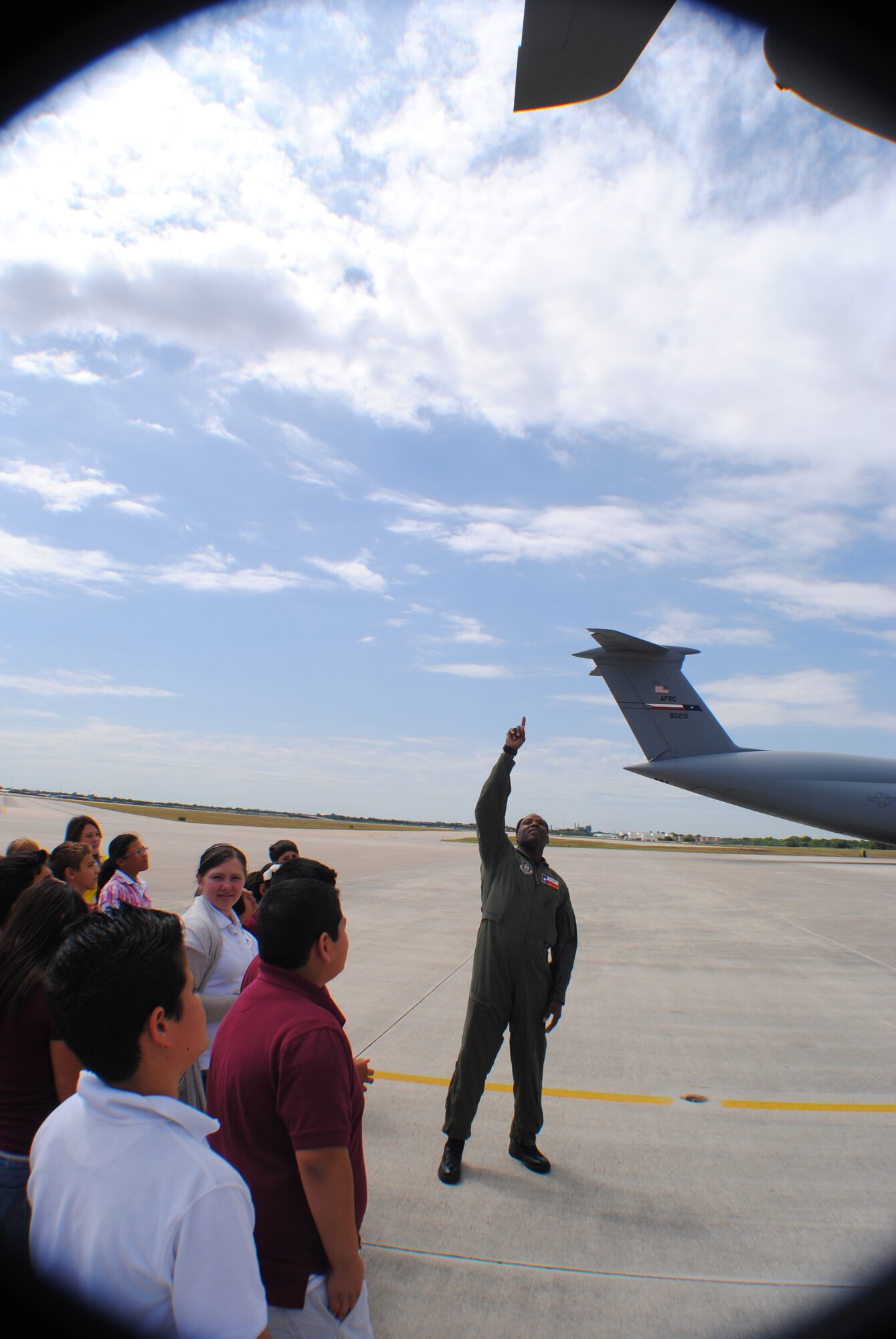 Master Sgt. R. Anthony Tippit, 68th Airlift Squadron loadmaster, points up to the tail of an aircraft while serving as a C-5 Galaxy tour guide for a group of sixth graders from Devine Middle School. From the ground to the top of its tail a C-5 Galaxy is approximately the as a five-story building. More than 120 middle school students and their teachers visited the 433rd Airlift Wing as part of a field trip to Lackland Air Force Base, Texas May 16. (U.S. Air Force photo/Senior Airman Luis Loza Gutierrez)