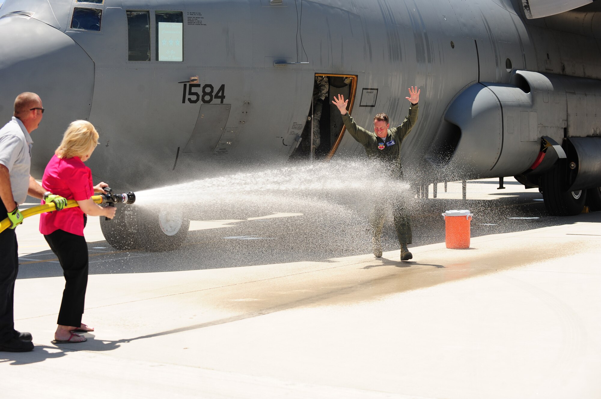 DAVIS-MONTHAN AIR FORCE BASE, Az. -- Lt. Gen. Glenn F. Spears, 12th Air Force commander is doused with water by his wife, Kim, after his fini flight on a 42nd Electronic Combat Squadron EC-130H Compass Call here May 6. General Spears served more than 33 years in the Air Force and was a command pilot with more than 3,400 flying hours in 16 types of aircraft. (Air Force photo by Senior Airman Jerilyn Quintanilla, 355th Fighter Wing Public Affairs)