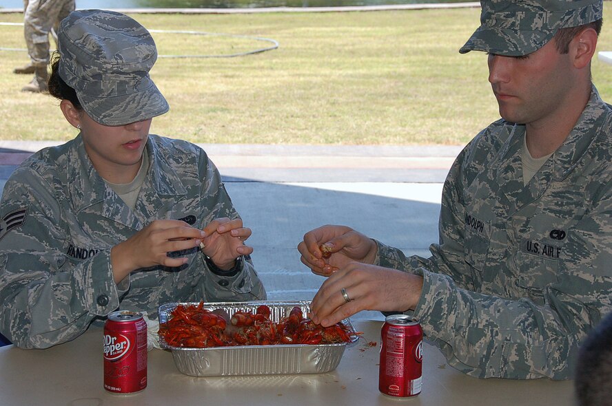Senior Airman Crystal Randolph, Headquarters Eighth Air Force, eats crawfish with her husband Staff Sgt. Casey Randolph, 2nd Maintenance Operations Squadron, during the 608th Strategic Operations Squadron crawfish boil at the Cyber Innovation Center in Bossier City, La., May 13. Crawfish season in Louisiana begins in March and continues through July. Louisiana supplies 98 percent of the crawfish harvested in the United States. (U.S. Air Force photo/Staff Sgt. Brian Stives)