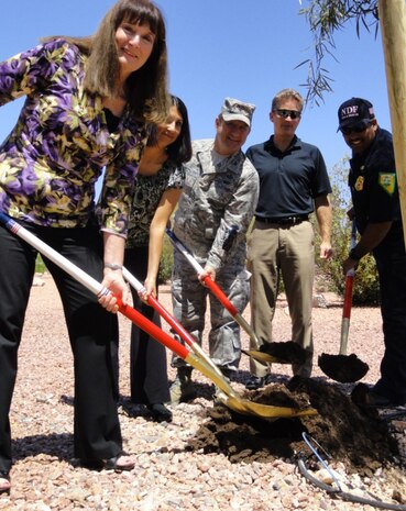 NELLIS AIR FORCE BASE, Nev.-- Col. Steven Winklmann, 99th Air Base Wing vice commander, plants an African Sumac with Deborah Stockdale, Susan Breckon, Douglas Fitzpatrick and Jorge Gonzales May 4 at the Maj. Gen. Billy McCoy Environmental Grove. The tree planting ceremony was held in honor of Arbor Day. (Courtesy photo)