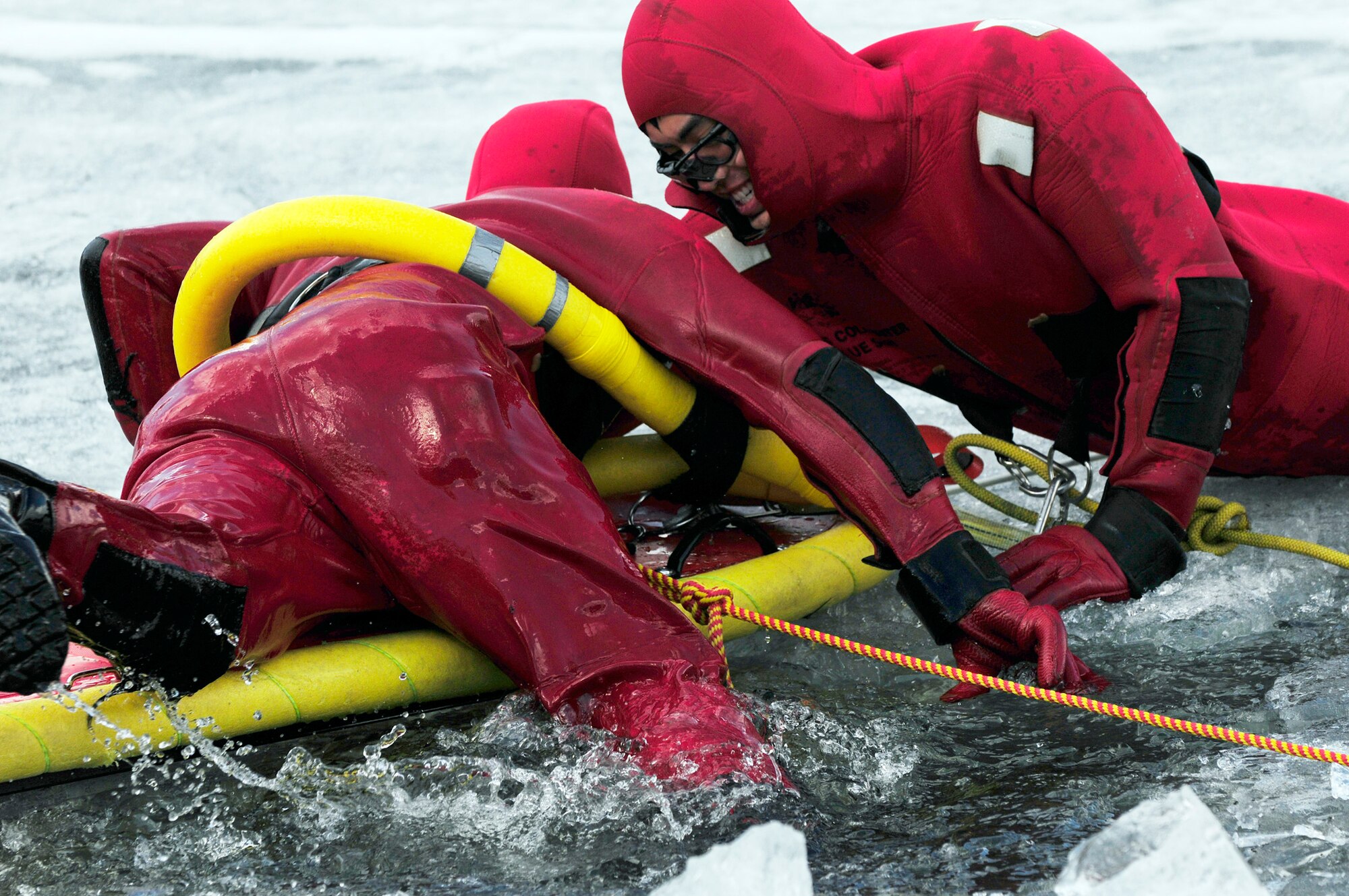 Airman 1st Class David Piasecki climbs out of a frozen lake onto a life raft that Senior Airman Bao Hoang stabilizes with his body during icy water rescue training May 6, 2011, at Eielson Air Force Base, Alaska. Airmen Hoang and Piasecki are fire fighters assigned to the 354th Civil Engineer Squadron Fire Protection Flight. (U.S. Air Force photo/Airman 1st Class Laura Goodgame)