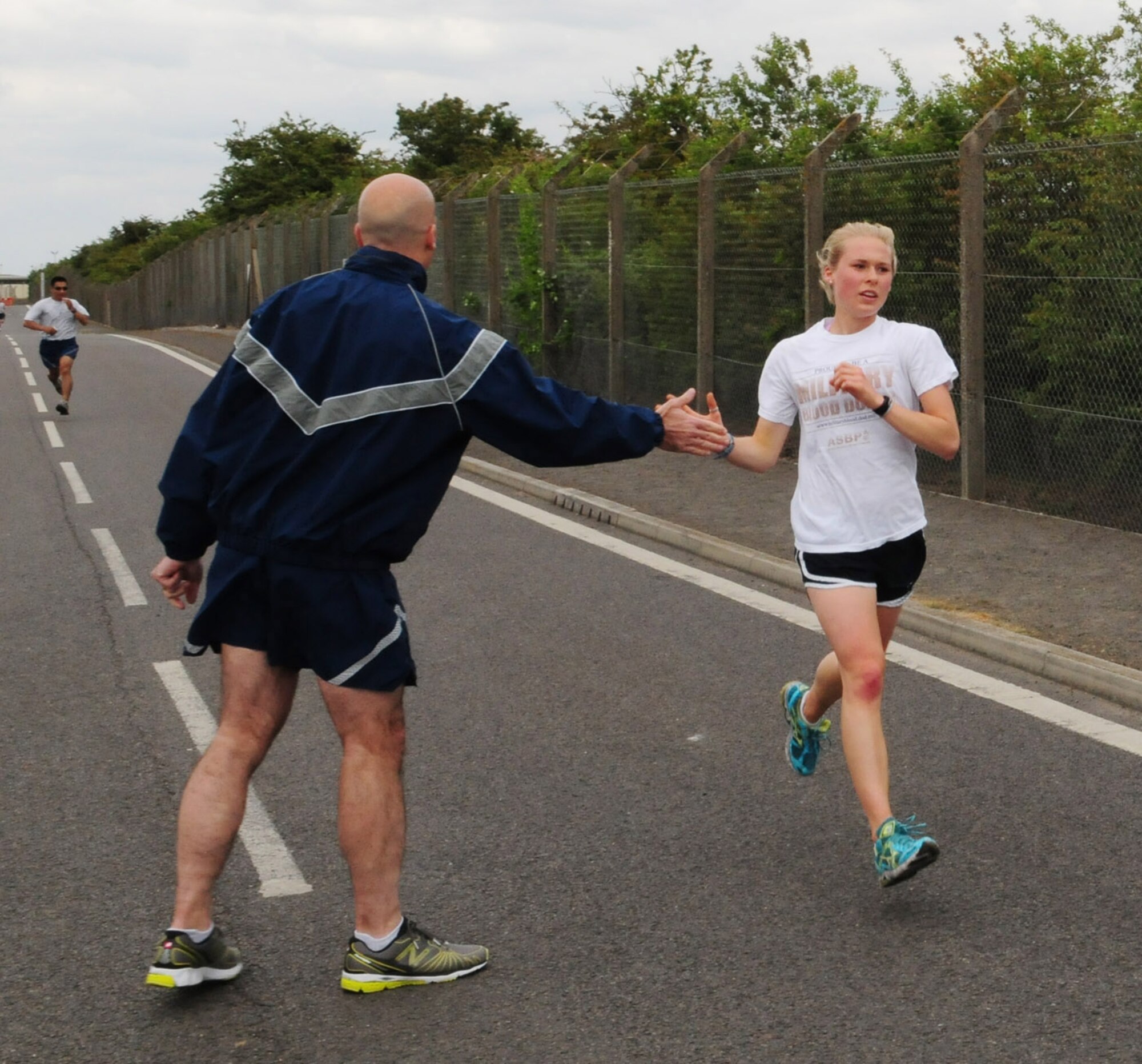 RAF MILDENHALL, England -- Elizabeth Doe, daughter of Col. David Doe, 100th Mission Support Group commander, gets a High Five from Col. Chad Manske, 100th Air Refueling Wing commander, as she gets ready to cross the finish line at the monthly 5K run May 13, 2011. Miss Doe was the first female across the finish line, with a time of 20:40. Staff Sgt. Danielle Todman, 100th Forces Support Squadron, was the second female with a time of 22:30, and Staff Sgt, Stephanie Maxwell, 100th Communications Squadron, placed third with a time of 23:08. (U.S. Air Force photo/Karen Abeyasekere)