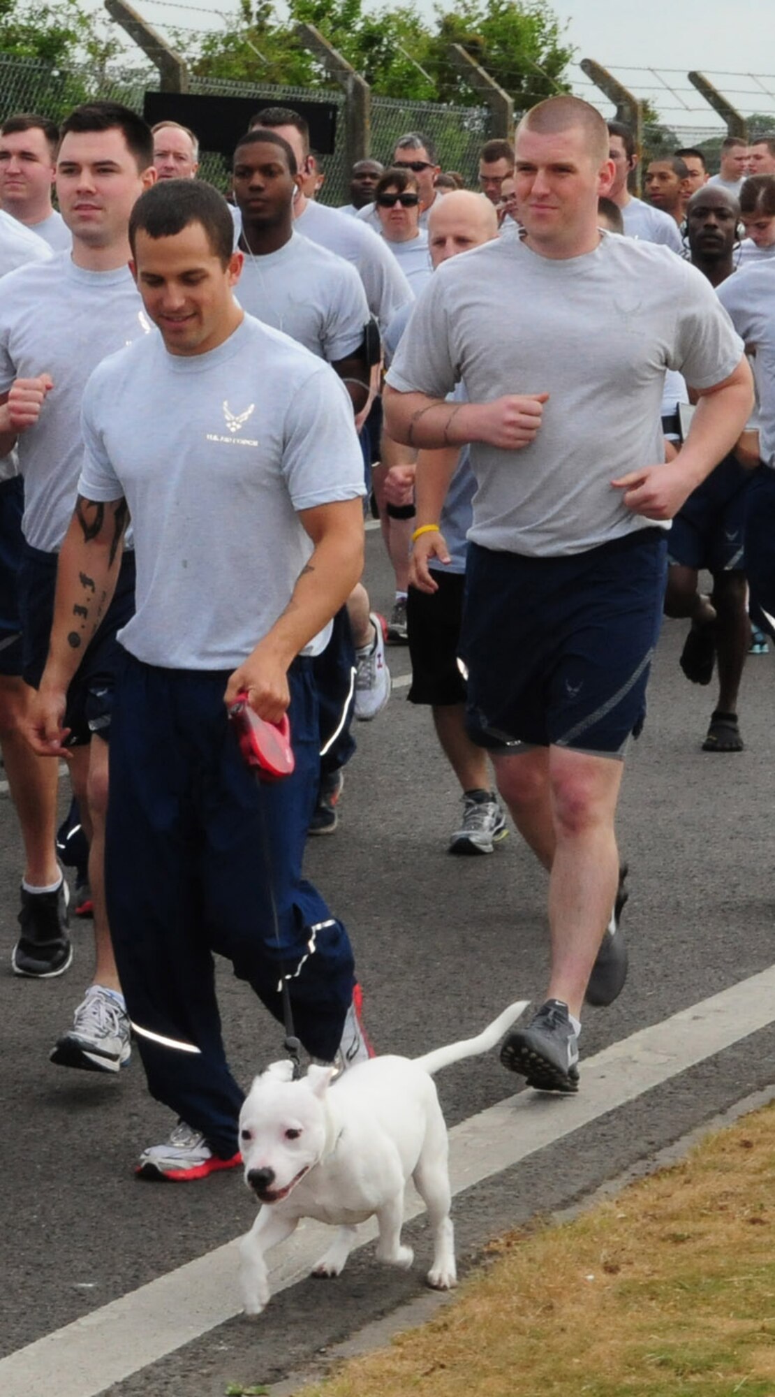 RAF MILDENHALL, England -- A Team Mildenhall member runs with his dog during the monthly 5K run May 13, 2011. Some family members also participated by pushing children in strollers along Perimeter Road, once all the runners had headed off towards the end of the flightline. (U.S. Air Force photo/Karen Abeyasekere)