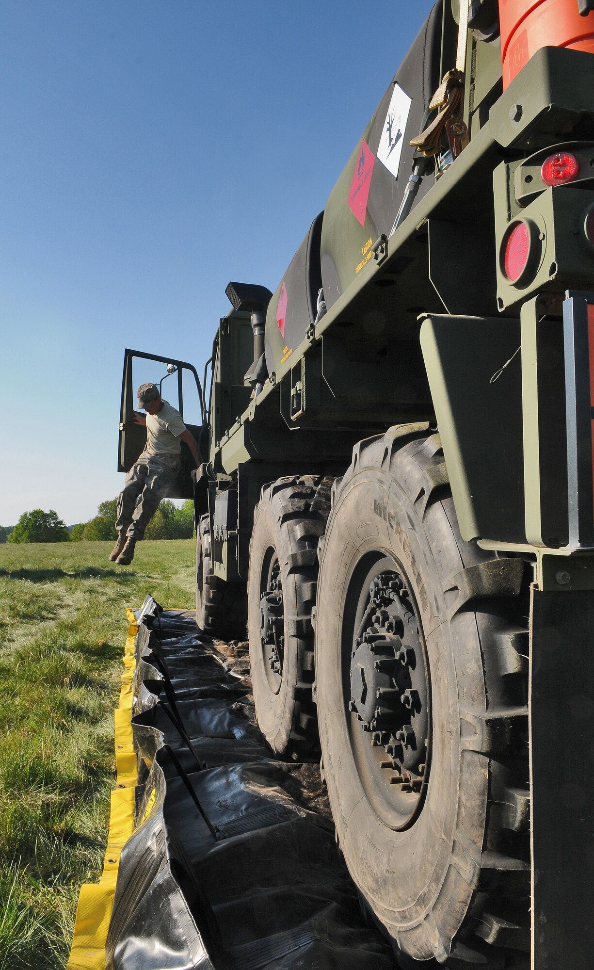 GEROLSTEIN, Germany – Staff Sgt. Dustin Smith, 606th Air Control Squadron power production journeyman, jumps out of a tactical vehicle after parking it on a plastic tarp to prevent oil from polluting the grass in case of an oil leak, as part of exercise Eifel Thunder 2011 in Gerolstein, Germany, May 9. The exercise tested the ability of Airmen to take all their equipment to an isolated location where they set up a deployed radar and satellite communications site as well as everything else required to survive and accomplish the mission in an isolated environment. (U.S. Air Force photo/Senior Airman Nick Wilson)