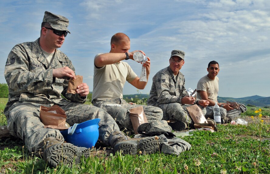 GEROLSTEIN, Germany – From left to right, Staff Sgt. William Blazejewski, 606th Air Control Squadron radio frequency transmission craftsman, Airman 1st Class Derek Paterson, 606th ACS radio frequency transmission apprentice, Senior Airman Cory Zylstra, 606th ACS radio frequency transmission journeyman, and Airman 1st Class Bobby Qermansha, 606th ACS radio frequency transmission journeyman, enjoy “Meals Ready to Eat” after arriving at an isolated location as part of the exercise Eifel Thunder 2011 in Gerolstein, Germany, May 9. The exercise tested the ability of Airmen to take all their equipment to an isolated location where they set up a deployed radar and satellite communications site as well as everything else required to survive and accomplish the mission in an isolated environment. (U.S. Air Force photo/Senior Airman Nick Wilson)