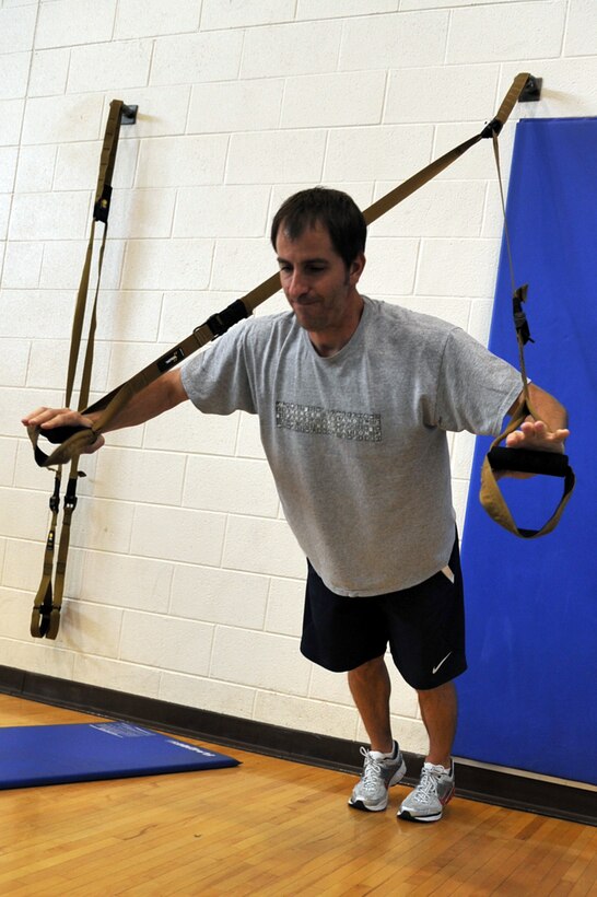 Jim Taccogno , spouse of 1st Lt. Sharee Taccogno, 633d Medical Group inpatient clinical nurse, performs a modified push-up with TRX suspension training equipment at Langley Air Force Base, Va., May 10, 2011.  TRX is a type of training in which you use your own body weight and gravity, to build strength, balance, coordination, flexibility, core and joint stability. (U.S. Air Force photo by Airman 1st Class Camilla Elizeu)(RELEASED) 