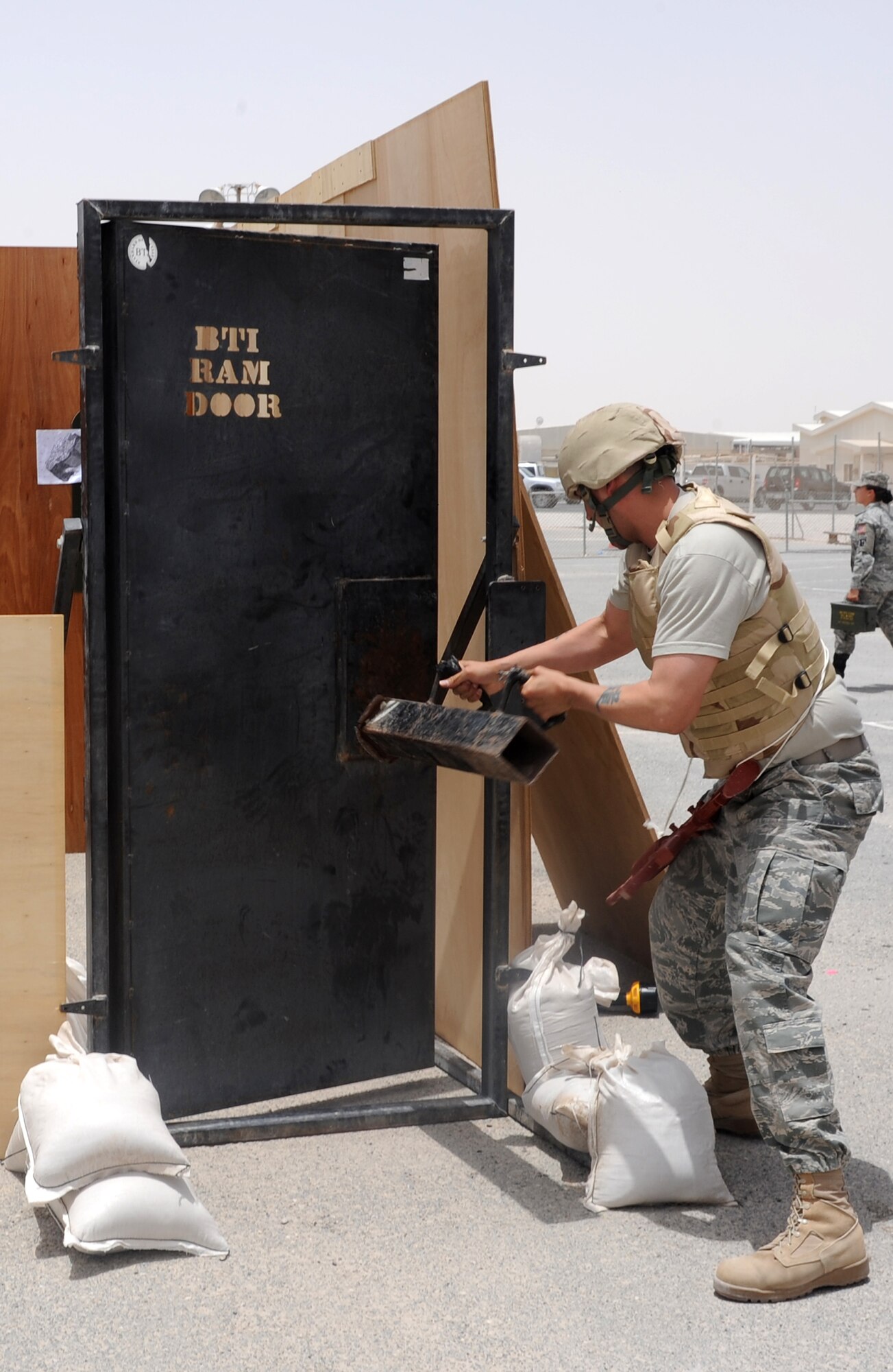 Staff Sgt. Benjamin Roa, 379th Air Expeditionary Wing Chaplain Assistant, practices breaking down doors during the Defenders Challenge competition at an undisclosed location in Southwest Asia, May 15. Police Week honors those who fell defending others and also educates participants on the roles of police and security forces. (U.S. Air Force photo/Staff Sgt. Liliana Moreno)