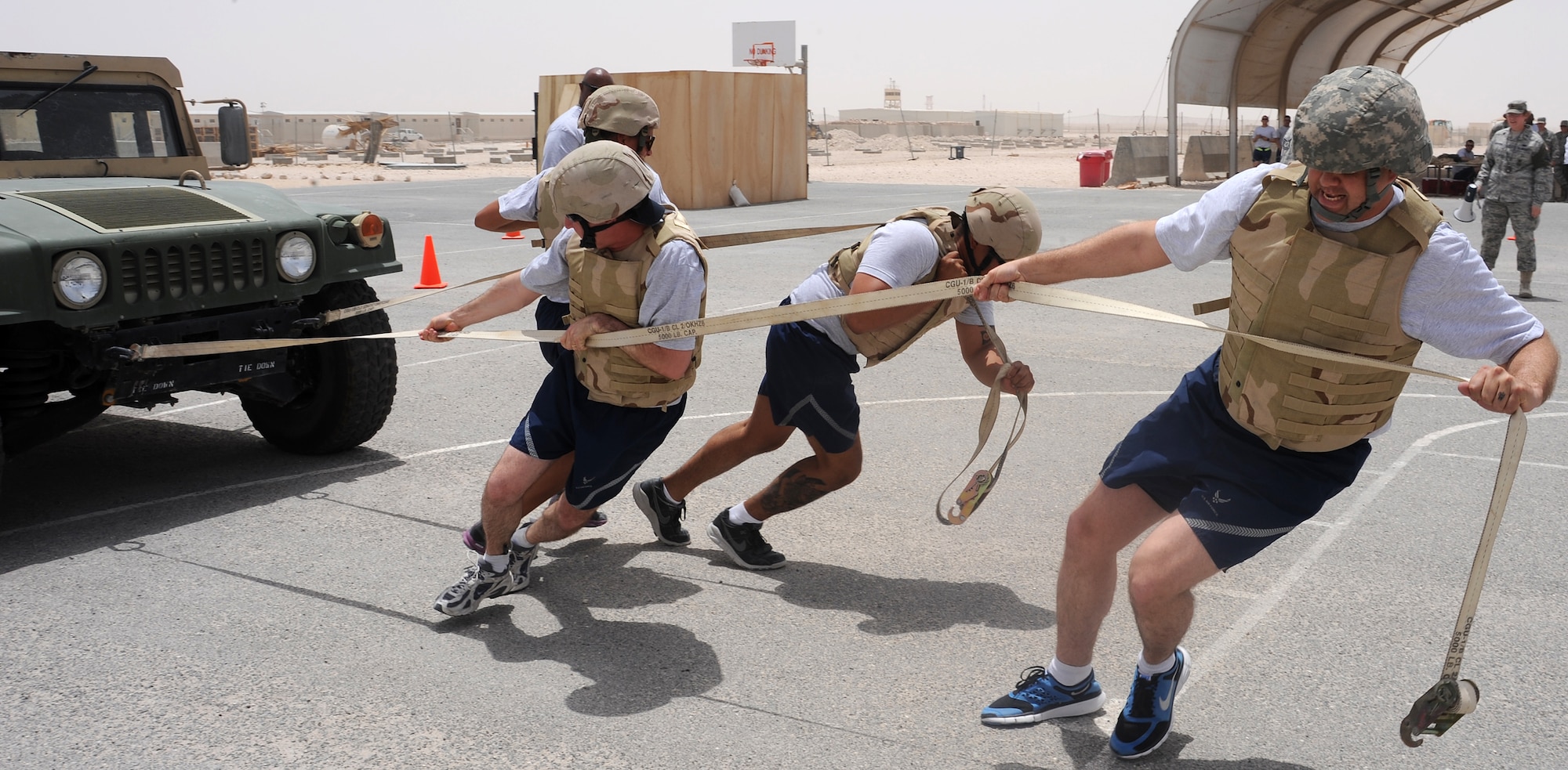 Master Sgt. David Hall, Staff Sgt. Alexa Ousley, Senior Airman Nathan Namauu and Master Sgt. Gregory Wasson pull a Humvee during the Defenders Challenge competition at an undisclosed location in Southwest Asia, May 15. Police Week honors those who fell defending others and also educates participants on the roles of police and security forces. (U.S. Air Force photo/Staff Sgt. Liliana Moreno)
