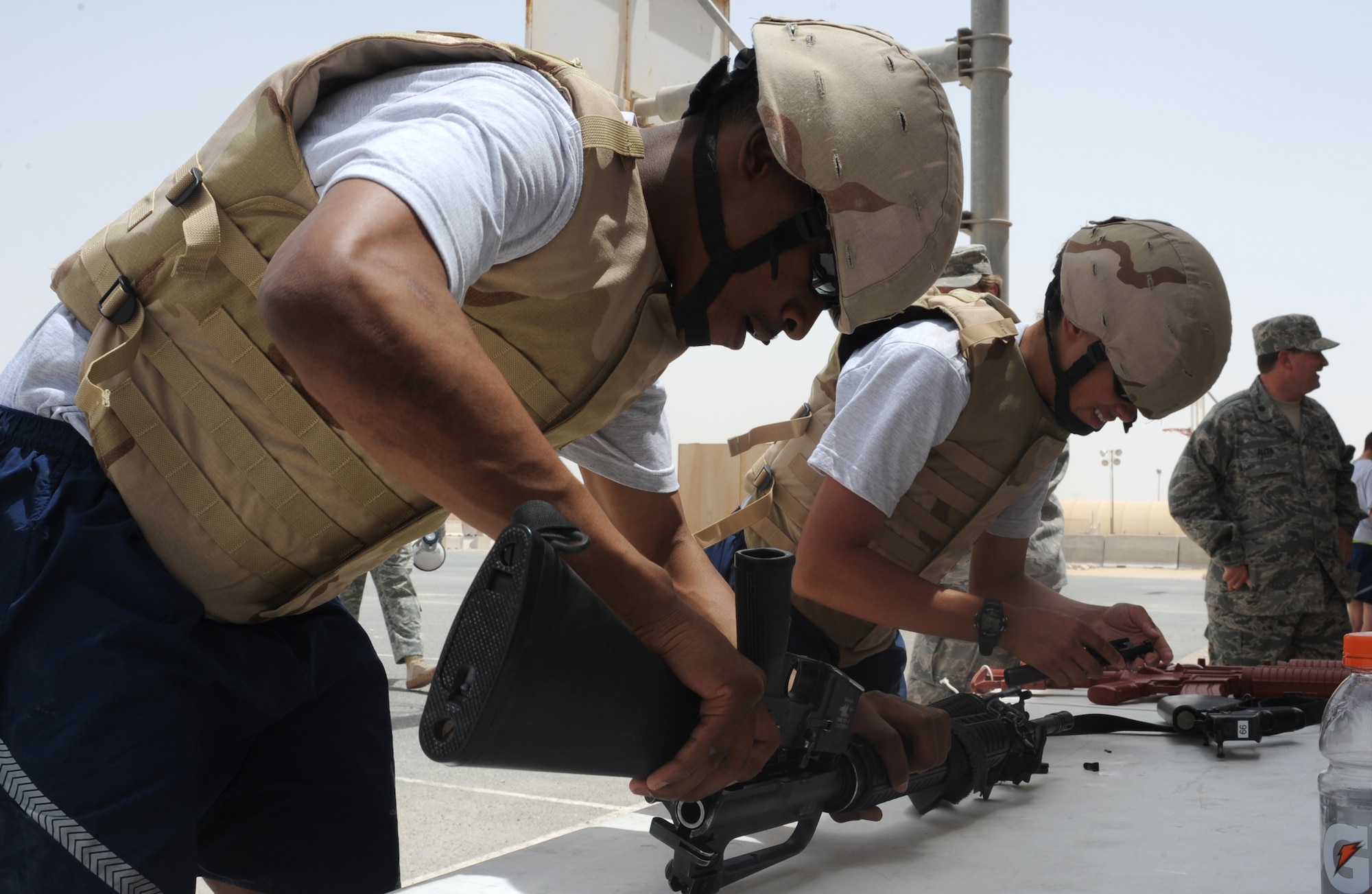 Senior Airmen Joseph Wells and Aurora Martin, 379th Expeditionary Security Forces Squadron, disassemble an M-16 riffle during the Defenders Challenge competition at an undisclosed location in Southwest Asia, May 15. A total of five teams competed in the Defenders challenge which consisted of numerous activities throughout the course. (U.S. Air Force photo/Staff Sgt. Liliana Moreno)