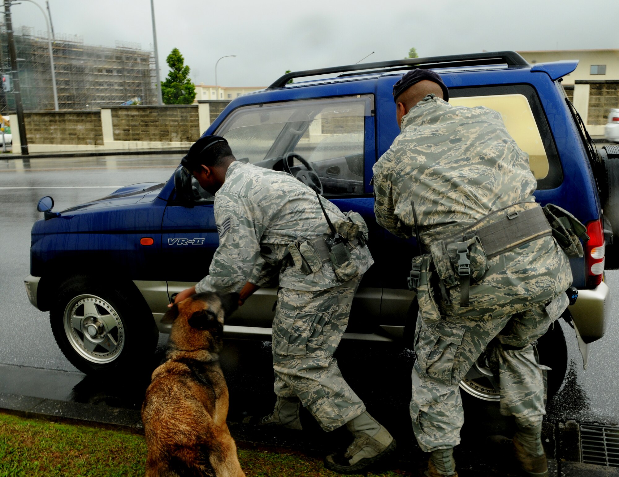 Staff Sgt. Sedale Berry, dog handler and Staff Sgt. Joseph Betancourt, a patrol officer, both with the 18th Security Forces Squadron, prepare to search an intruder's car that sped through a secured entry point, as part of of an exercise May 16, at Kadena Air Base, Japan. Kadena personnel are participating in Exercise Beverly High 11-04 to stay prepared for real world contingencies. (U.S. Air Force photo/Airman 1st Class Jarvie Z. Wallace)