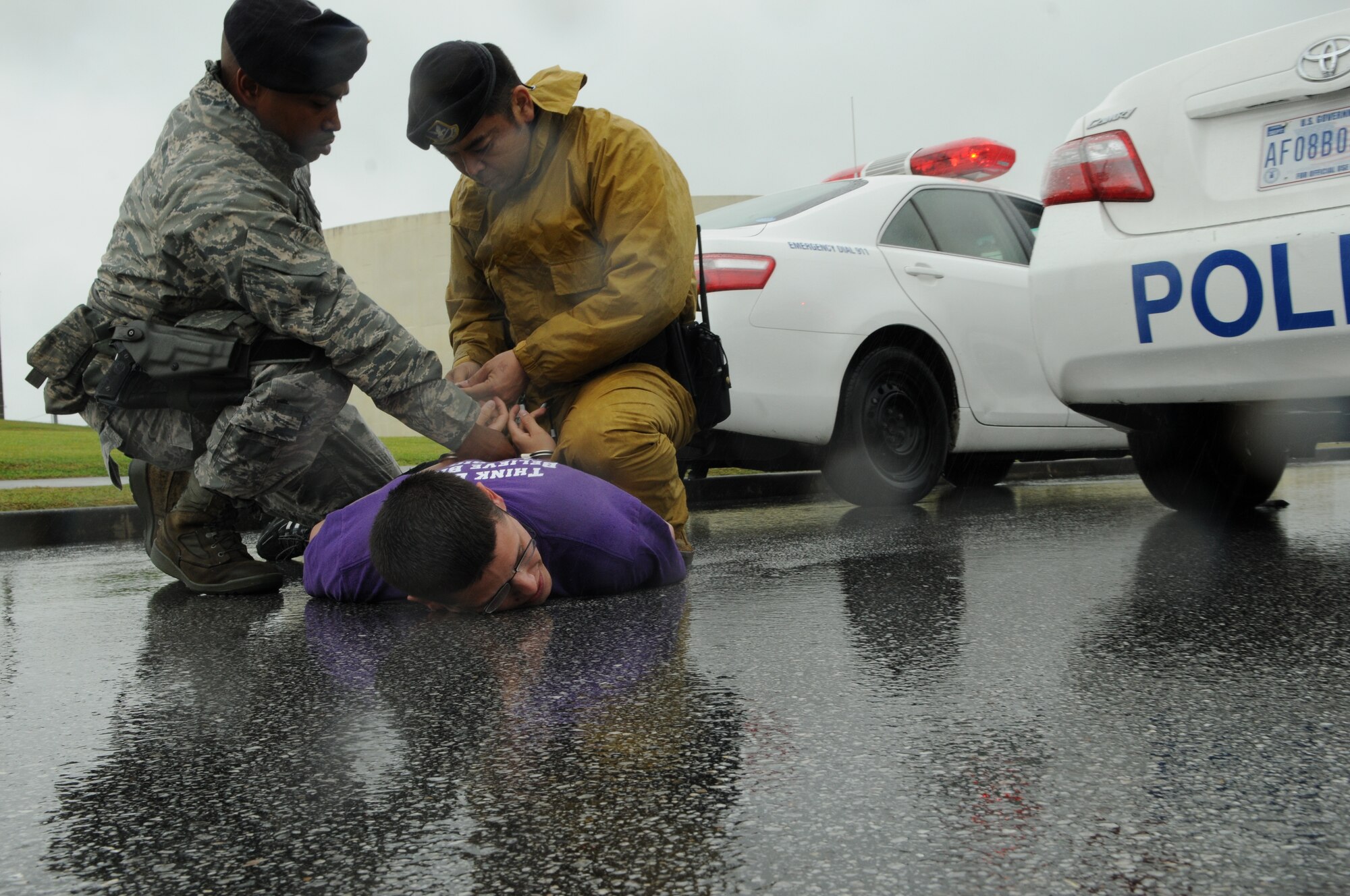 Satoshi Higa, a civilian guard with the 18th Security Forces Squadron and Staff Sgt. Joseph Betancourt, a patrol officer with the 18th SFS apprehend an intruder, who broke through an entry gate as part of an exercise, May 16, at Kadena Air Base, Japan. Kadena's personnel are participating in Exercise Beverly High 11-04 to stay prepared for real world contingencies. (U.S. Air Force photo/Airman 1st Class Jarvie Z. Wallace)