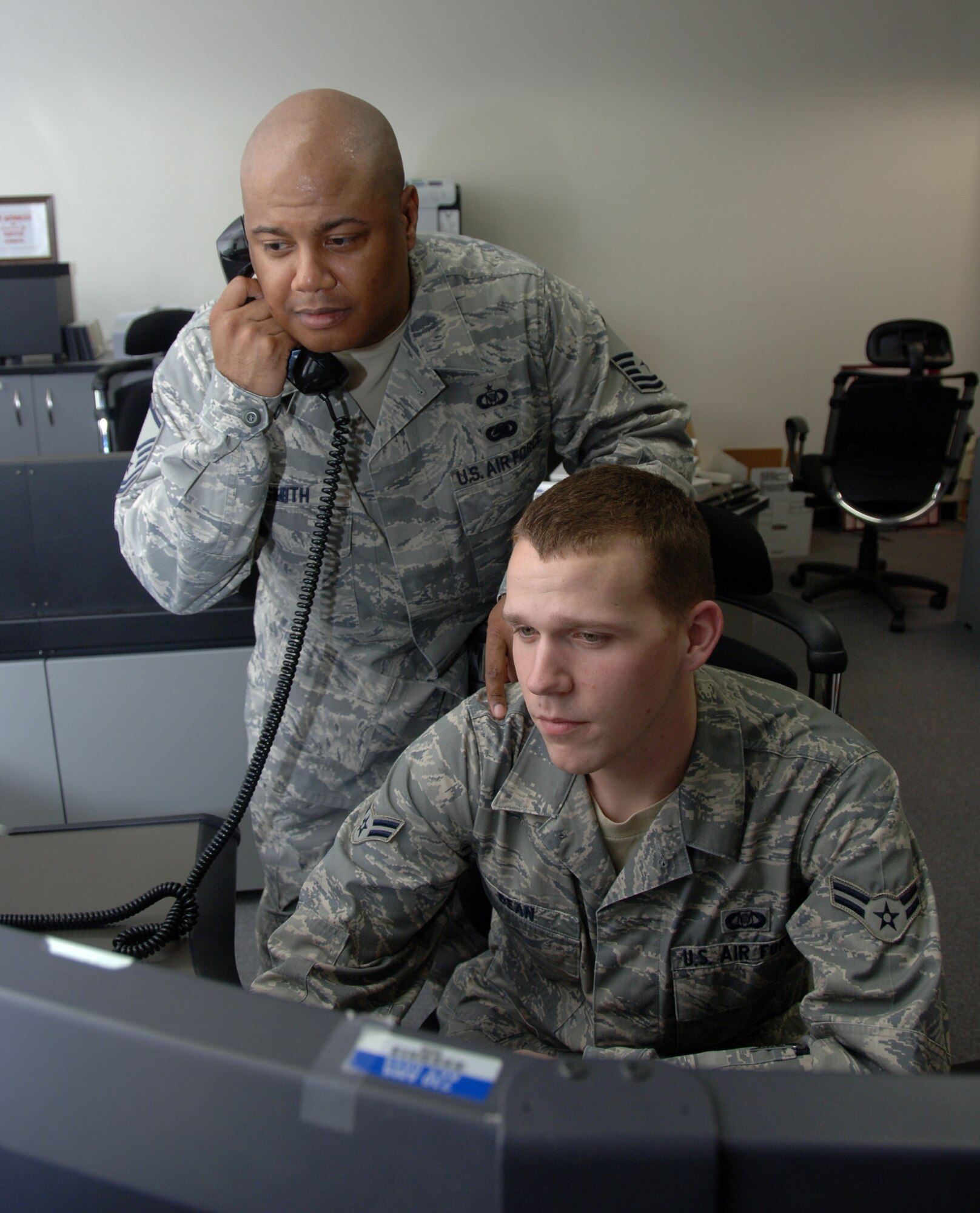YOKOTA AIR BASE, Japan -- Master Sgt. Gregory Smith, 730th Air Mobility Squadron Air Mobility Command Center superintendent (left), reviews flight data with Airman 1st Class Matthew Bean, 730th AMS airlift operations controller, at Yokota Air Base, Japan, May 13, 2011. Sergeant Smith was recognized as the Air Force Command Post Senior NCO of the Year for 2010. (U.S. Air Force Photo/Airman 1st Class Katrina R. Menchaca)
