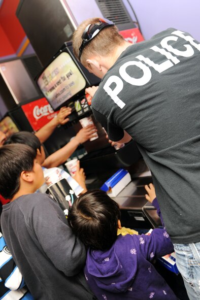 KUNSAN AIR BASE, Republic of Korea -- A member of the 8th Security Forces Squadron helps children from the from the Samsung Orphanage get soft drinks before a movie during their visit here May 14. After a K-9 demonstration the children enjoyed popcorn, hotdogs, a movie and bowling with security forces Airmen. (U.S. Air Force photo/Senior Airman Brittany Y. Bateman)