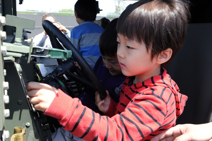 KUNSAN AIR BASE, Republic of Korea -- Children from the Samsung Orphanage play with the 8th Security Forces Squadron police vehicles during their visit here May 14. After a K-9 demonstration the children enjoyed popcorn, hotdogs, a movie and bowling with security forces Airmen. (U.S. Air Force photo/Senior Airman Brittany Y. Bateman)