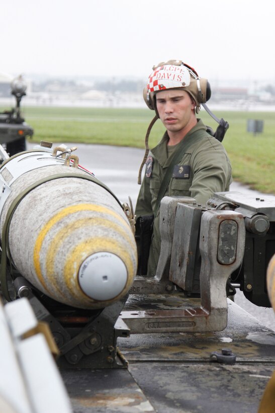 Lance Cpl. Matthew A. Davis, a Marine All Weather Fighter Attack Squadron 533 ordnance technician, guides the forks of the munitions laoder into muinitions handling unit for a guided bomb unit 32 joint direct attack muintions 1,000 pound bomb here May 16. The munitions loader is a fork lift type vehicle, which help the ordnance technicians load bombs to the aircraft.