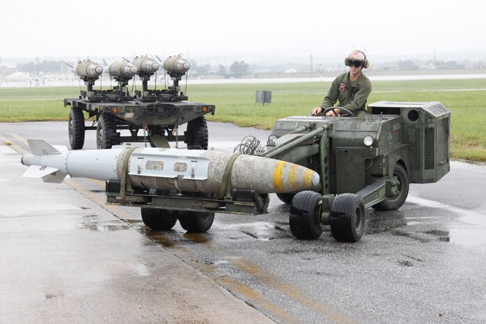 Cpl. Drew H. Carley, a Marine All Weather Fighter Attack Squadron 533 ordnance technician, drives the munitions loader with  a guided bomb unit 32 joint direct attack muintions 1,000 pound bomb here May 16. The munitions loader, a fork lift type vehicle, transports the bombs with ease and precision.