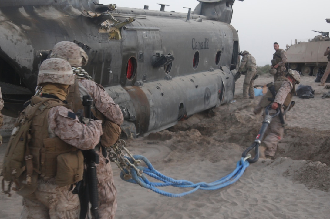 Helicopter support team Marines with 2nd Marine Logistics Group prepare the rigging for a transport of a Canadian Forces CH-47 Chinook helicopter during a tactical recovery of aircraft and personnel mission in Kandahar Province, Afghanistan, May 17. The Marines and Canadian Forces were able to transport the injured aircraft back home safely to Kandahar Airfield, Afghanistan.