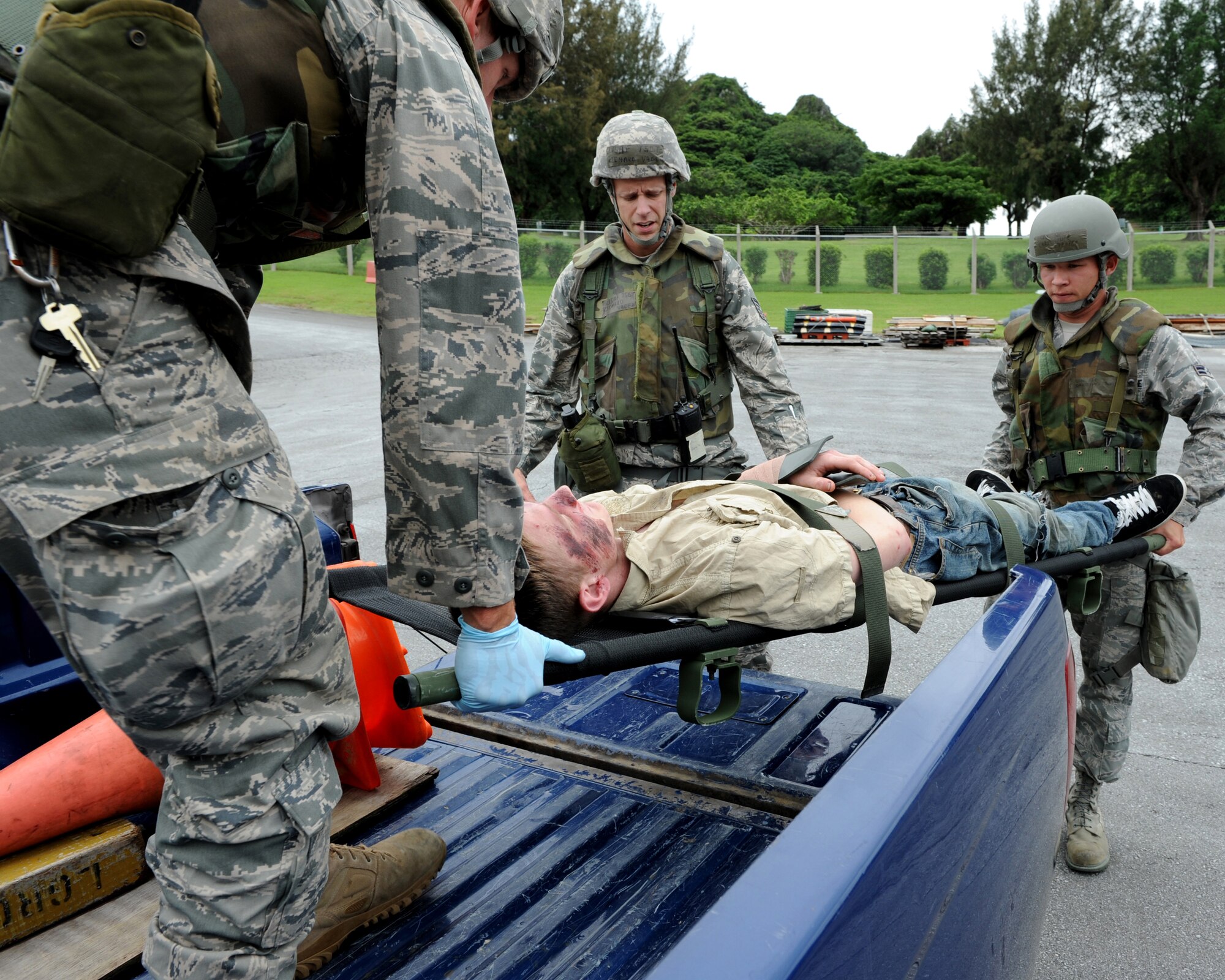 Senior Airman Cory Hasik (left), Tech. Sgt. Richard Vaden (center),  Airman 1st Class Christopher Draper (right), all from the 18 Civil Engineer Squadron, move an “injured” Airman 1st Class Malix Britton, 18th Equipment Maintenance Squadron, who is simulating being hit by a truck as part of local operational readiness exercise Beverly High 11-4, May 17, at Kadena Air Base, Japan.17, at Kadena Air Base, Japan. Kadena's personnel are participating in exercise Beverly High 11-04 to stay prepared for real world contingencies. (U.S. Air Force photo/Junko Kinjo)