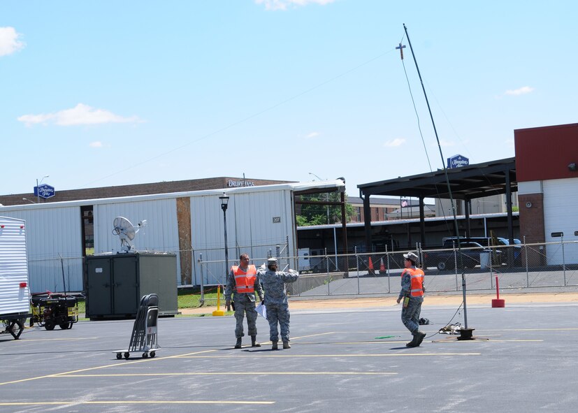 Members of the 131st Bomb Wing at Lambert-Saint Louis Air National Guard Base participate in the Cracked Earth national level exercise designed to prepare and coordinate a multi-jurisdictional integrated response to national catastrophic events such as an earthquake at the New Madrid fault-line in Missouri.  Team members confer on the installation of a satellite up-link, May 16.  (Photo by master Sgt. Mary-Dale Amison)