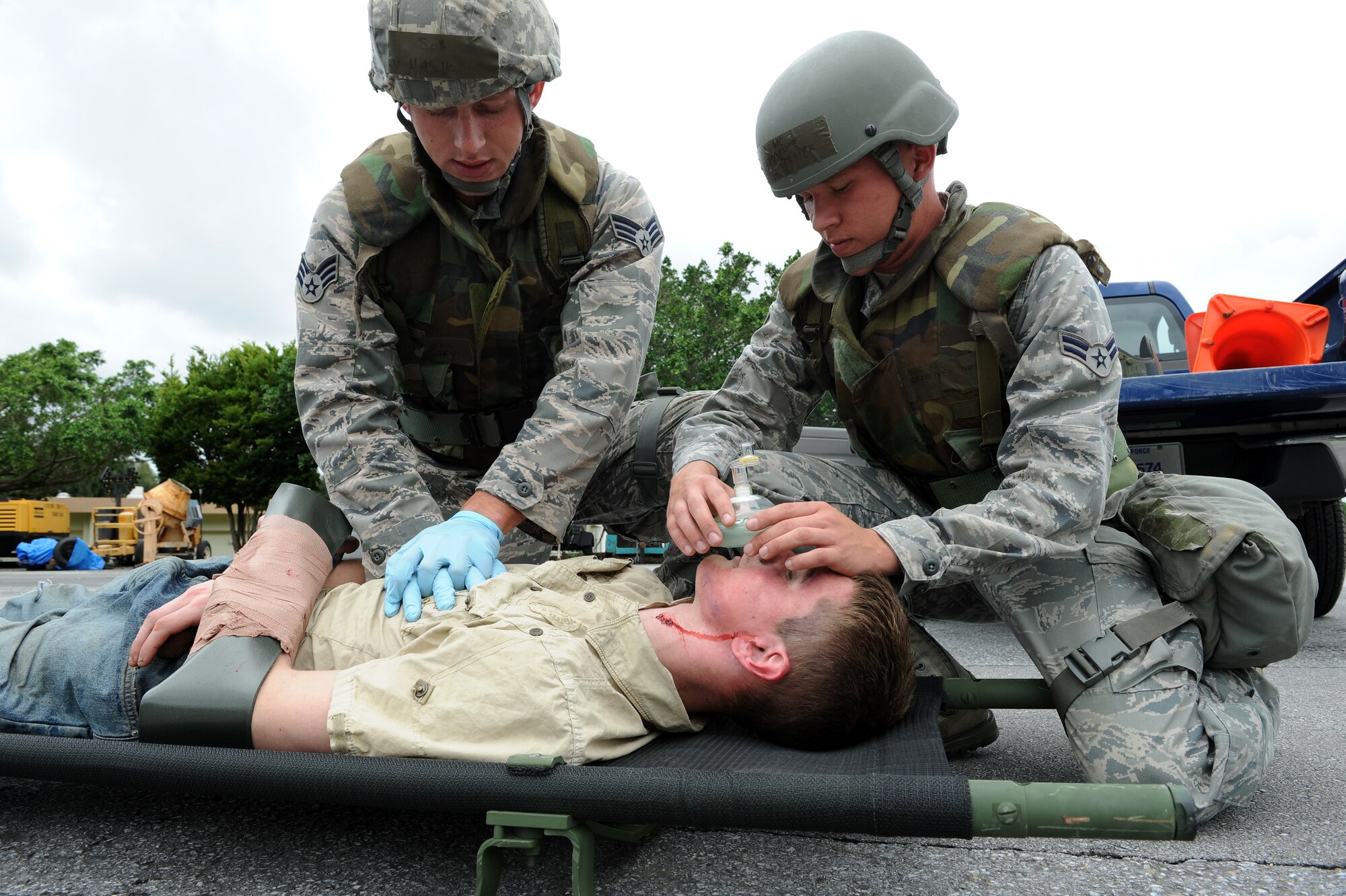 Senior Airman Cory Hasik (left) and Airman 1st Class Christopher Draper (right), both from the 18th Civil Engineer Squadron, give Cardiopulmonary Resuscitation to “injured” Airman 1st Class Malix Britton, 18th Equipment Maintenance Squadron, who is simulating being hit by a truck as part of local operational readiness exercise Beverly High 11-4, May 17, at Kadena Air Base, Japan. Kadena's personnel are participating in the LORE to stay prepared for real world contingencies. (U.S. Air Force photo/Junko Kinjo)
