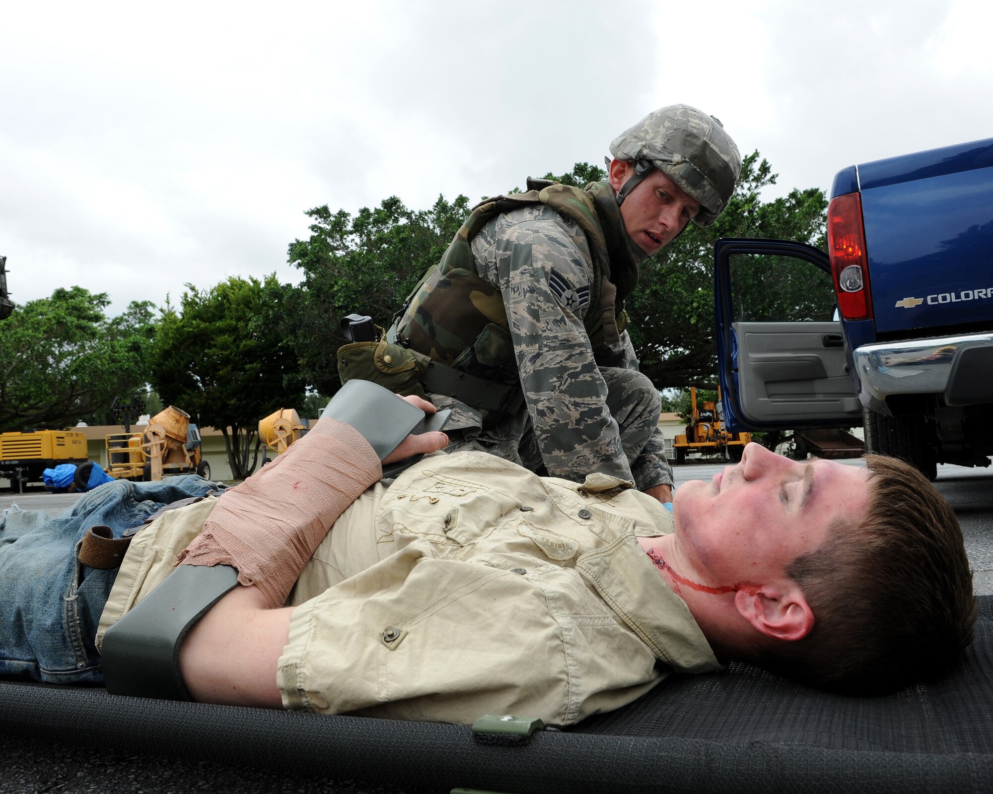 Senior Airman Cory Hasik, 18th Civil Engineer Squadron, applies self aid and buddy care to “injured” Airman 1st Class Malix Britton, 18th Equipment Maintenance Squadron, who is simulating being hit by a truck as part of local operational readiness exercise Beverly High 11-4, May 17, at Kadena Air Base, Japan. Kadena's personnel are participating in the LORE to stay prepared for real world contingencies. (U.S. Air Force photo/Junko Kinjo)
