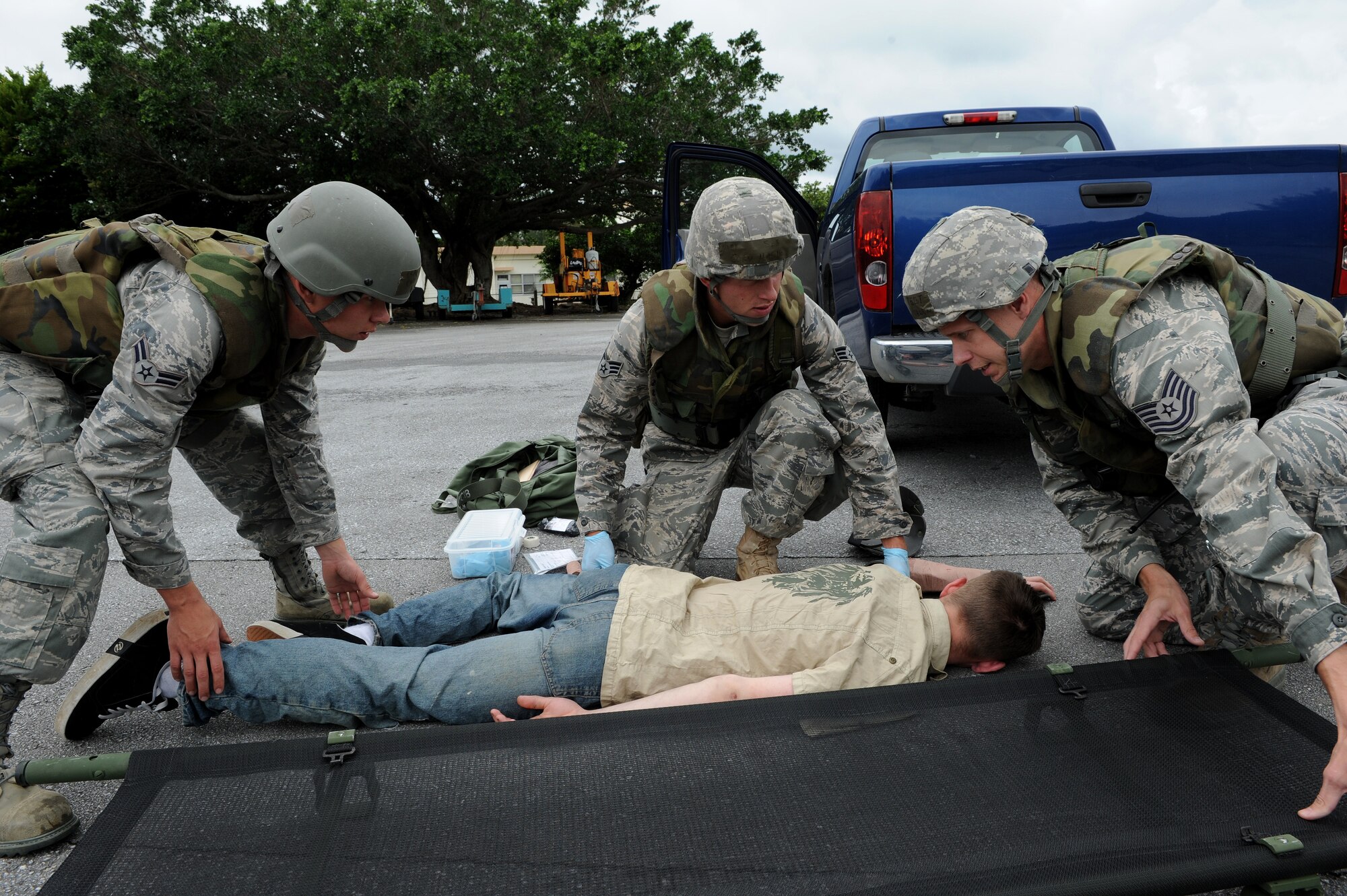 Airman 1st Class Christopher Draper (left), Senior Airman Cory Hasik (center), and Tech. Sgt. Richard Vaden (right), all from the 18th Civil Engineer Squadron, prepare to move an “injured” Airman 1st Class Malix Britton, 18th Equipment Maintenance Squadron, who is simulating being hit by a truck as part of local operational readiness exercise Beverly High 11-4, May 17, at Kadena Air Base, Japan. Kadena's personnel are participating in the LORE to stay prepared for real world contingencies. (U.S. Air Force photo/Junko Kinjo)