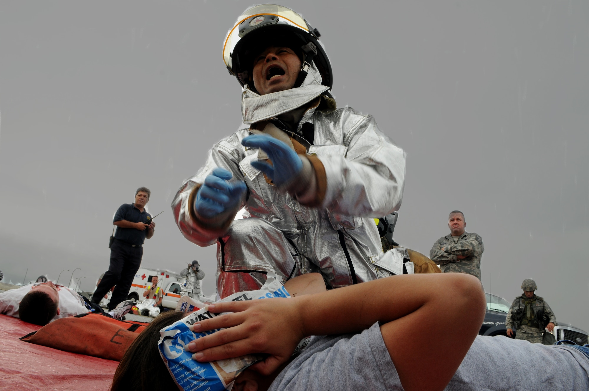 Yasuhira Oshiro, a fireman from the 18th Civil Engineer Squadron, prvovides aid to "injured" victims who were extracted from a simulated burning E-3 sentry aircraft, May 17 at Kadena Air Base, Japan. The simulated engine fire was part of Beverly High 11-04, a local operational readiness exercise, and tested the fire department’s ability to respond to an aircraft fire. (U.S. Air Force photo/Airman 1st Class Jarvie Z. Wallace)