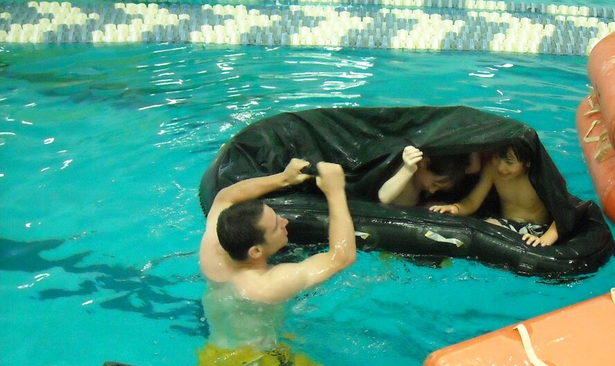 Tech. Sgt. Ian Gardner, 916th Aircrew Flight Equipment shop, demonstrates the spray shield on a life raft to children at a community-wide event in mid-May. (USAF photo courtesy of 916AFE)