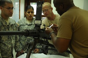 SOTO CANO AIR BASE, Honduras - Joint Task Force-Bravo had nine members attend and successfully complete the Unit Armors Certification Course May 9-13. Here Specialist Angelia Mowery observes as instructor, Sergeant 1st Class Jack Graves explains head space and timing on a .50 cal machine gun. (U.S. Air Froce photo/Staff Sgt. Kimberly Rae Moore)
