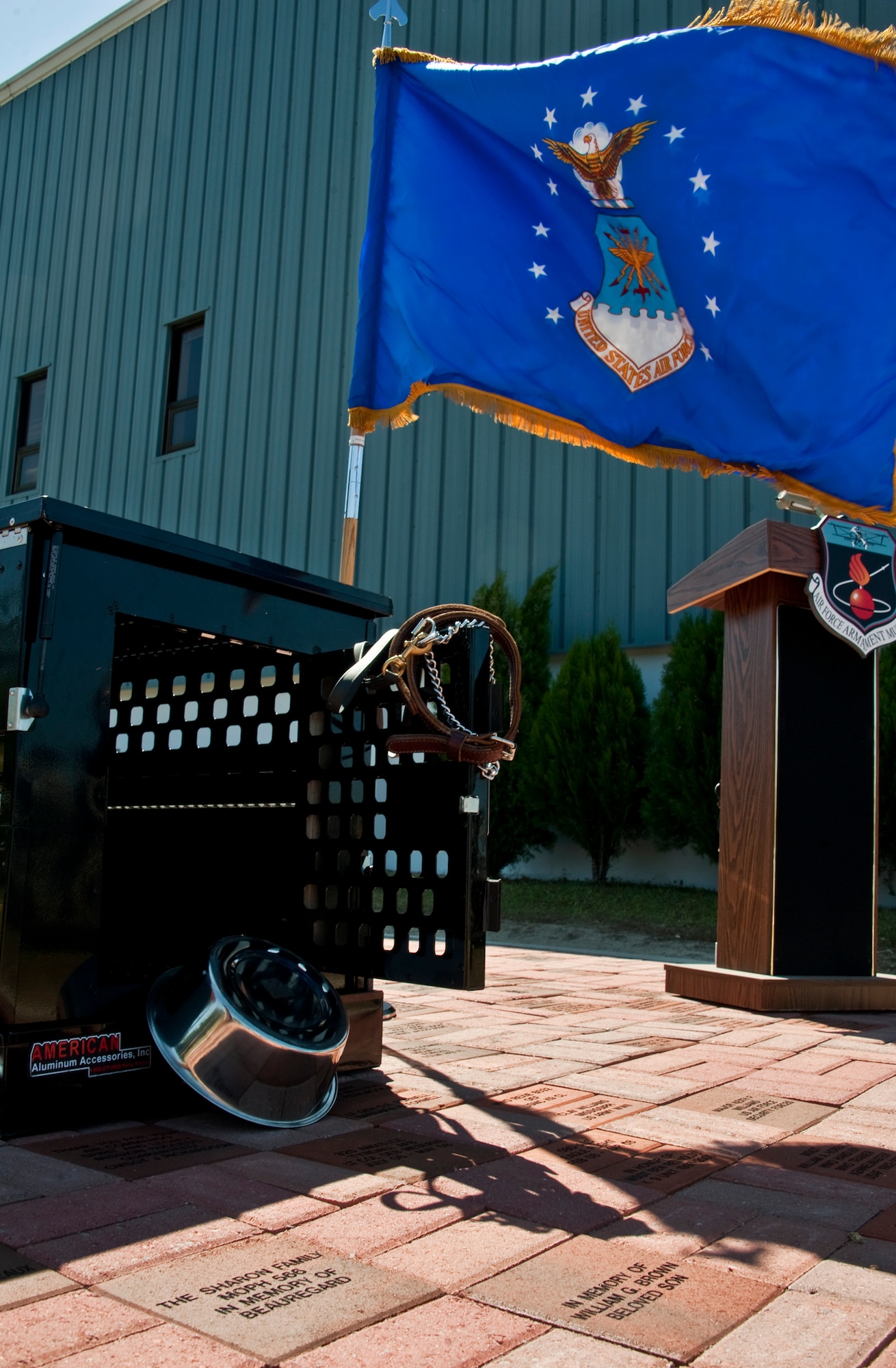 A gust of wind unfurls the Air Force flag as it stands beside the “combat kennel” at the site of the Military Working Dog memorial ceremony May 17 at the Air Armament Museum.  The ceremony honored MWDs and civilian K-9 unit for their service and remembered those who’ve fallen.  The ceremony was just one of the events happened for Police Week.  (U.S. Air Force photo/Samuel King Jr.)    

 
