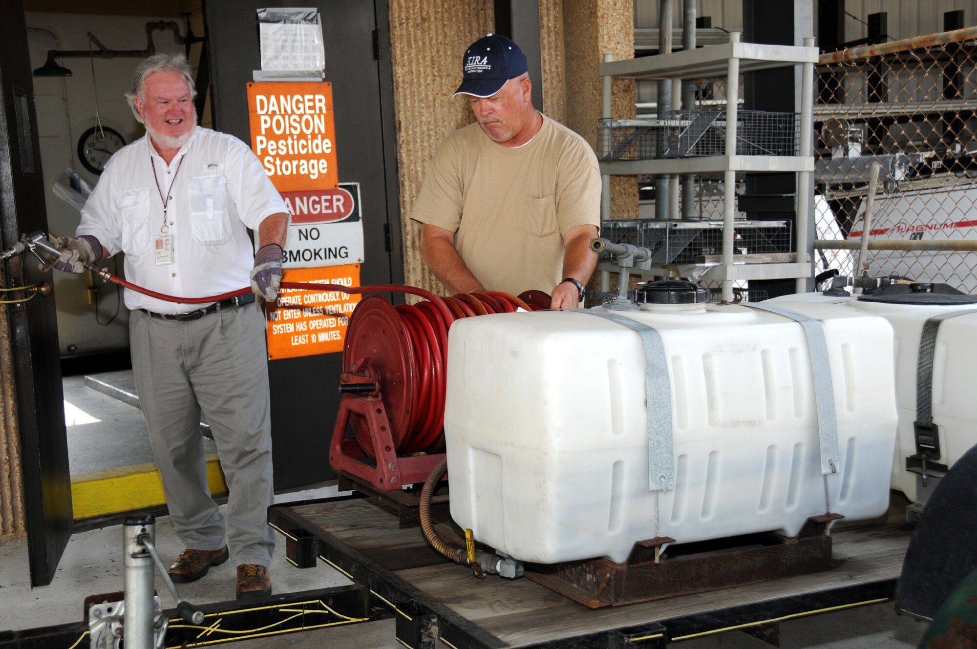 Mr. Remel, left, and Mr. Thomas prepare herbicide to control weeds.  (U.S. Air Force photo by Kemberly Groue)