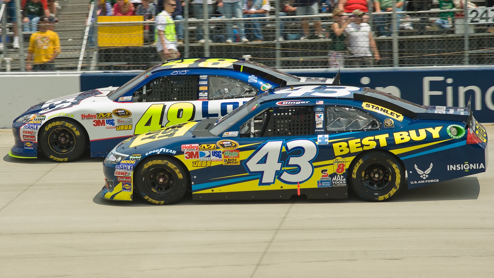 The No. 48 car and driver Jimmie Johnson (left) were slightly ahead of the No. 43 car, co-sponsored by the U. S. Air Force, and driver A.J. Allmendinger, when the first caution flag came out May 15, 2011, at Dover International Speedway, Del. Mr. Allmendinger and his No. 43 car withdrew from the FedEx 400 benefiting Autism Speaks due to engine problems later in the race. (U.S. Air Force photo by Airman 1st Class Jacob Morgan)