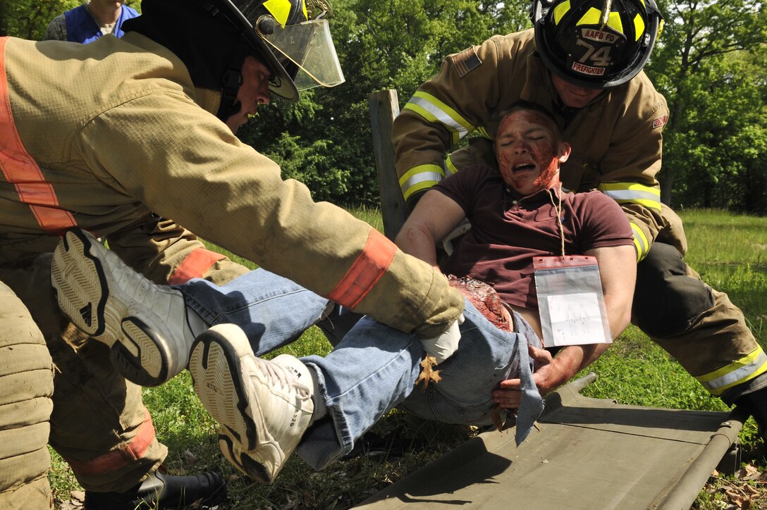 11th Civil Engineer Squadron firefighters move an injured patient to a litter during a mass-causality exercise May 12. During the exercise Airmen’s skills were honed in the event a similar incident occurs during the Joint Service Open House. JSOH is slated to extend from May 20th through May 22nd.  (U.S. Air Force Photo by Senior Airman Perry Aston) (Released)