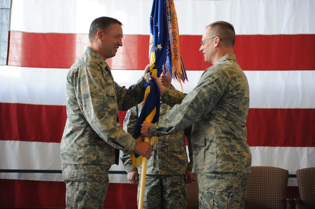 Brig. Gen. Jon Norman, 12th Air Force vice commander, passes the 28th Bomb Wing guidon to Col. Mark Weatherington, 28th Bomb Wing commander, as he assumes command of the 28th Bomb Wing, May 13. With a decade of back-to-back combat deployments; a first ever B1B Lancer global strike in Libya and a constant churn of individual augmentees the 28th Bomb Wing enjoys a rich combat heritage. (U.S. Air Force photo/Senior Airman Adam Grant)  