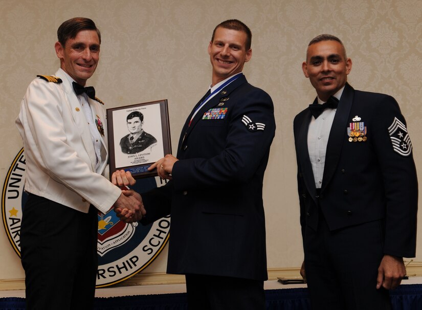 Capt. Ralph Ward and Chief Master Sgt. Jose LugoSantiago present the John L. Levitow Award to Senior Airman Michael Ault during the Airman Leadership School Class graduation May 12. The award is given for a student's exemplary demonstration of excellence, both as a leader and a scholar. Captain Ward is the Joint Base Charleston deputy commander and Chief LugoSantiago is the 628th Air Base Wing command chief. Airman Ault is an explosive ordnance disposal journeyman assigned to the 628th Civil Engineer Squadron. (U.S. Air Force photo/Senior Airman Katie Geiratz)

