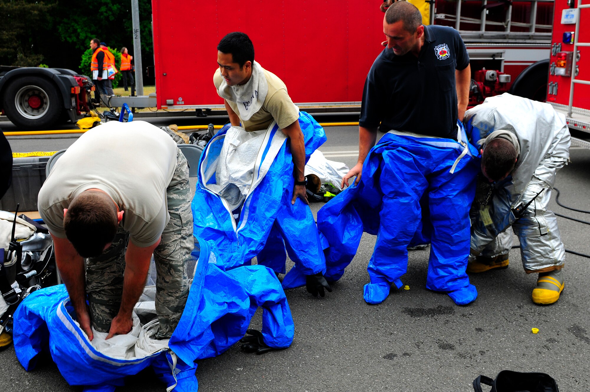 U.S. Air Force 886th Civil Engineer Squadron firefighters don hazemat suits before responding to a vehicle explosion during an operational readiness exercise on Ramstein Air Base, Germany, May 17, 2011. An ORE incorporates a series of scenarios to evaluate a base's ability to execute operational duties under various crisis response scenarios. (U.S. Air Force Photo by Airman 1st Class Brea Miller)