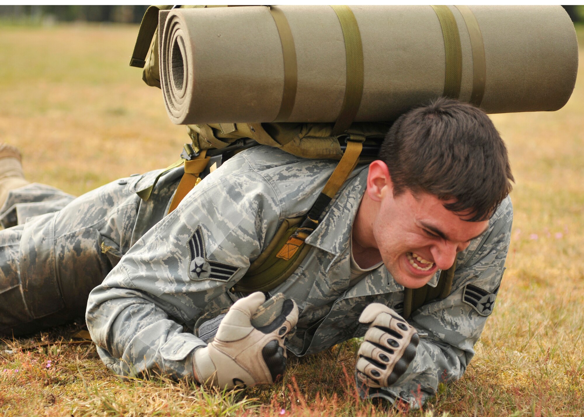 ROYAL AIR FORCE LAKENHEATH, England – Senior Airman Ben Forbus, 48th Security Forces Squadron patrolman, high crawls with a 35 pound ruck sack during the 5K Combat Ruck March Challenge on May 17, 2011. This is one of several events that will be held during National Police Week at RAF Lakenheath to honor police officers.  The challenge required the teams to race between four checkpoints: 25 push-ups, high crawl, memory game and fireman carry. Out of the seven competing teams, Airman Forbus’ team finished first with a time of 36 minutes and 25 seconds. (U.S. Air Force photo/Senior Airman Tiffany M. Deuel)