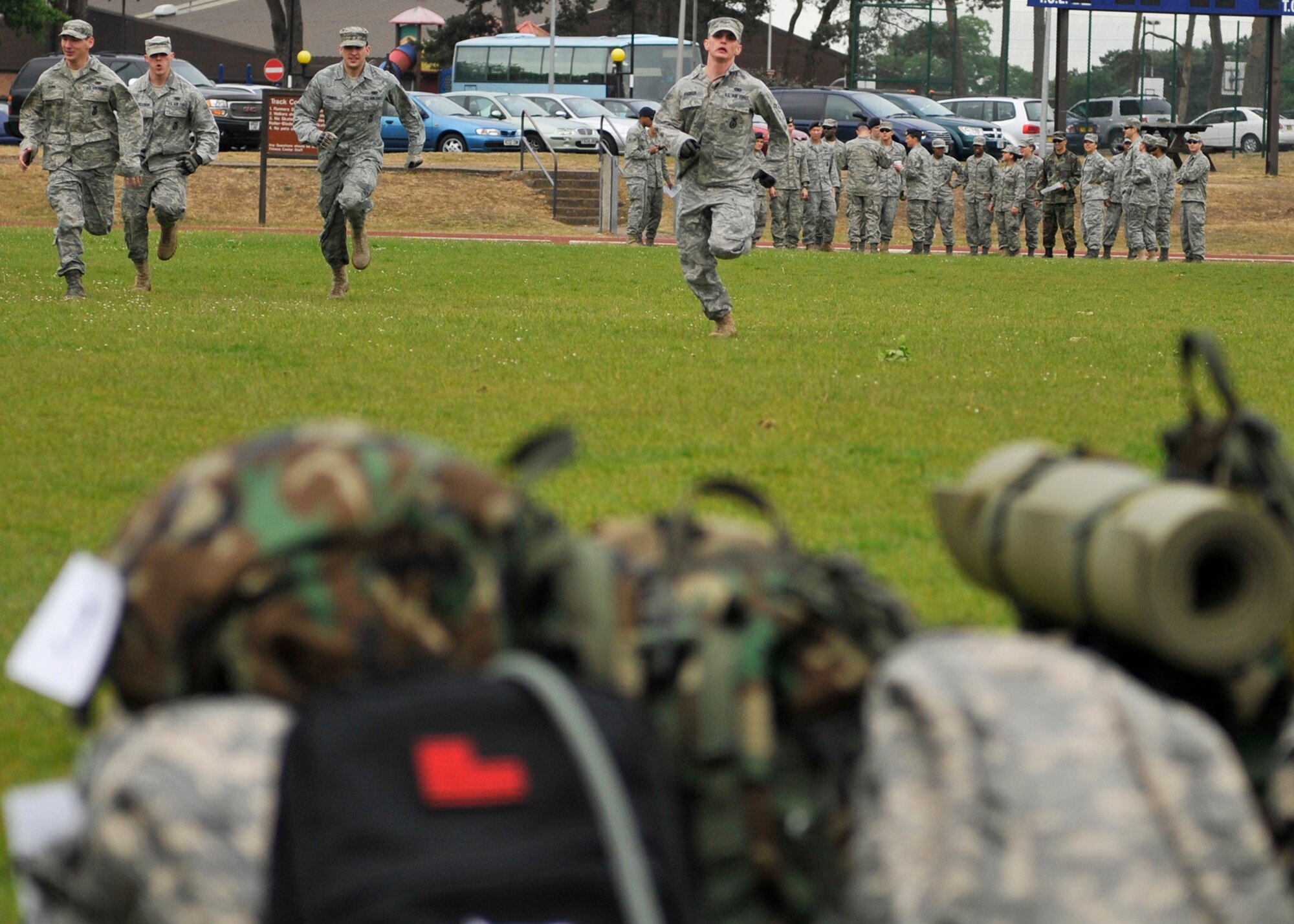 ROYAL AIR FORCE LAKENHEATH, England – Team One, consisting of four 48th Security Forces Squadron Airmen, race to grab their ruck sacks at the beginning of the 5K Combat Ruck March Challenge, May 17, 2011.  This is one of several events that will be held during National Police Week at RAF Lakenheath to honor police officers. Each ruck sack weighed 35 pounds and were carried throughout the entire challenge. During the challenge, the seven teams were staggered 3 minutes apart to properly gauge times. Team One finished in first place with the time of 36 minutes and 25 seconds. (U.S. Air Force photo/Senior Airman Tiffany M. Deuel)