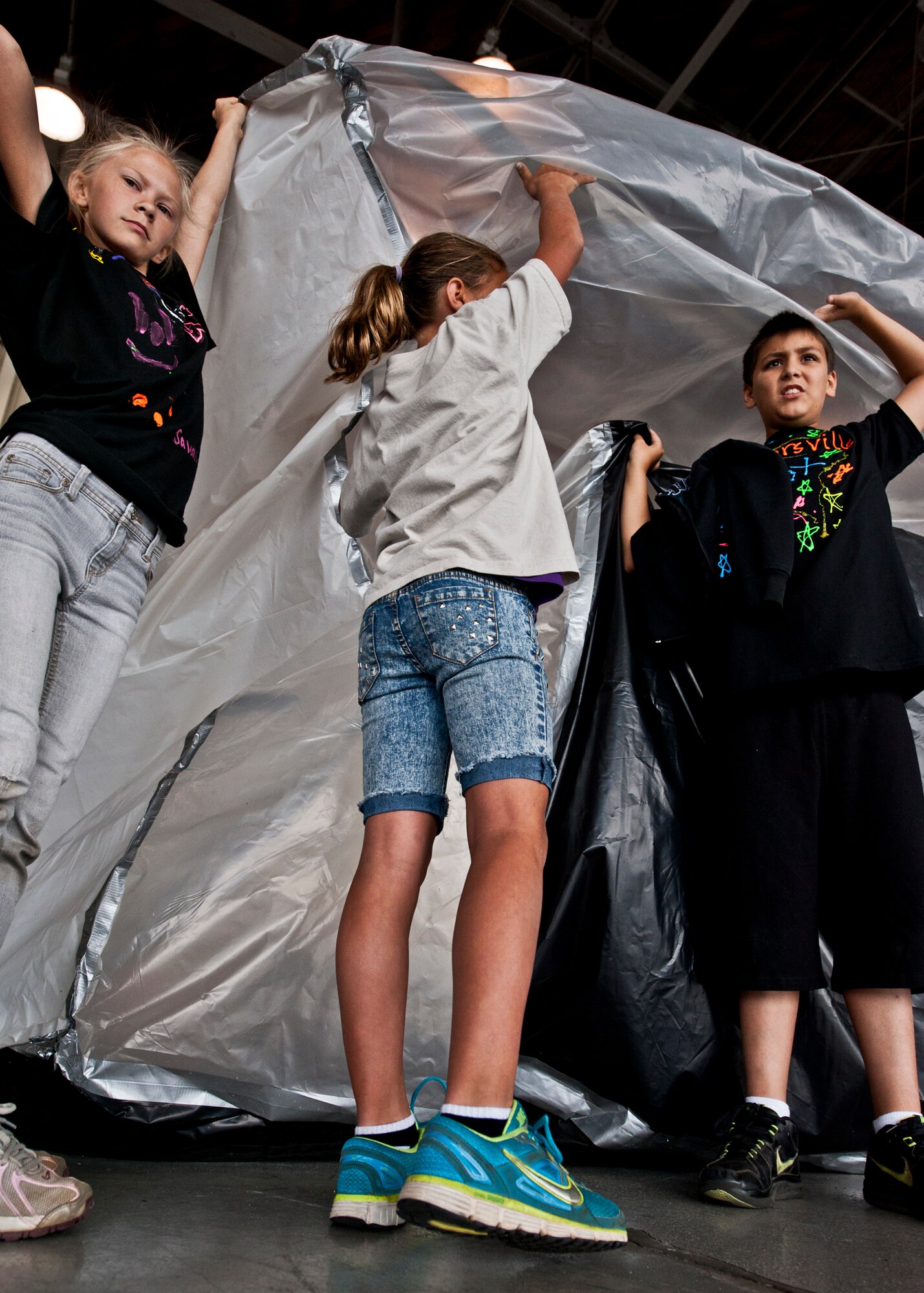 Children begin to lift their Pod to a standing position in Hangar 422 during Eglin’s annual “Marsville” event for local fifth graders May 16.  More than 120 students from Wright, Longwood Elementary and Lewis Middle schools gathered on Eglin for a single mission: build a life-sustaining pod on Mars. The 16th annual event is a collaborative effort between Eglin and the surrounding community's elementary school fifth-grade students, and faculty members. One of its top goals is to encourage students to pursue careers in science and engineering.  (U.S. Air Force photo/Samuel King Jr.)