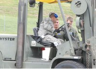 Senior Airman Mark Hansen, 700th Airlift Squadron loadmaster, briefs Tech. Sgt. Antonio Manning, 80th Aerial Port Squadron Ramp Services supervisor, during a training exercise involving the movement of cargo to and from a C-130.  (U.S. Air Force photo/Master Sgt. Stan Coleman)