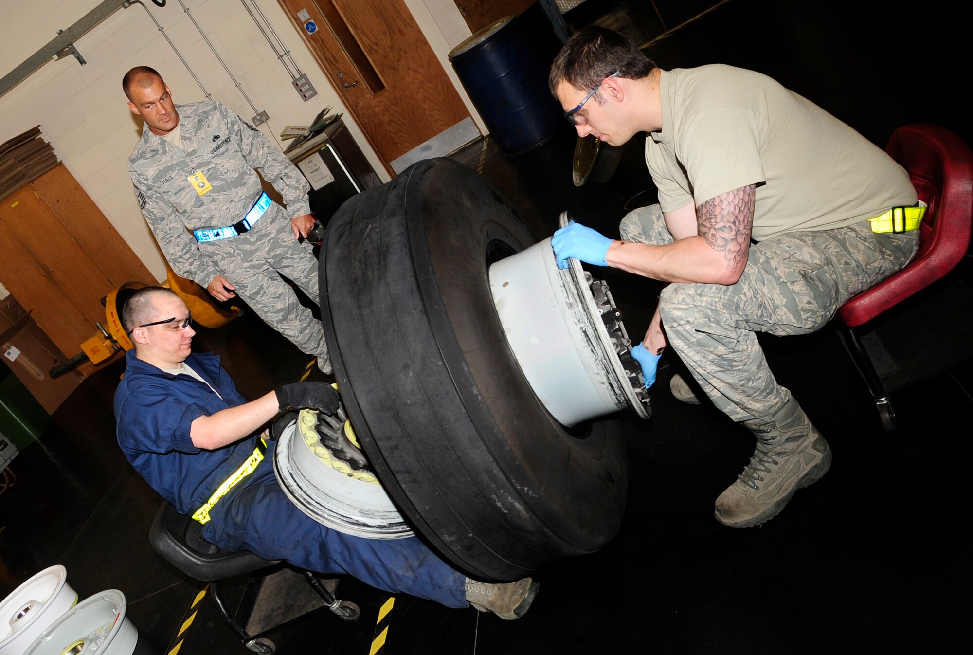 RAF MILDENHALL, England -- Senior Master Sgt. Monty Hall, U.S. Air Forces in Europe Inspector General Inspection Team associate inspector, monitors Senior Airman Joseph Cid, and Staff Sgt. Dustin Neal, both 100th Maintenance Squadrons aerospace technicians, as they disassemble a KC-135 Stratotanker carbon wheel, to verify compliance during the base compliance inspection here May 17, 2011. The UCI is held every three years for each base, to evaluate areas mandated by law, as well as mission areas, identified by senior Air Force and major command leadership as critical or important to the health and performance of a unit meet an acceptable standard. (U.S. Air Force photo/Senior Airman Ethan Morgan)