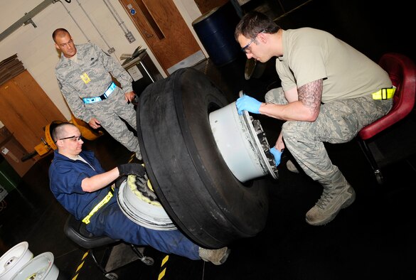 RAF MILDENHALL, England -- Senior Master Sgt. Monty Hall, U.S. Air Forces in Europe Inspector General Inspection Team associate inspector, monitors Senior Airman Joseph Cid, and Staff Sgt. Dustin Neal, both 100th Maintenance Squadrons aerospace technicians, as they disassemble a KC-135 Stratotanker carbon wheel, to verify compliance during the base compliance inspection here May 17, 2011. The UCI is held every three years for each base, to evaluate areas mandated by law, as well as mission areas, identified by senior Air Force and major command leadership as critical or important to the health and performance of a unit meet an acceptable standard. (U.S. Air Force photo/Senior Airman Ethan Morgan)
